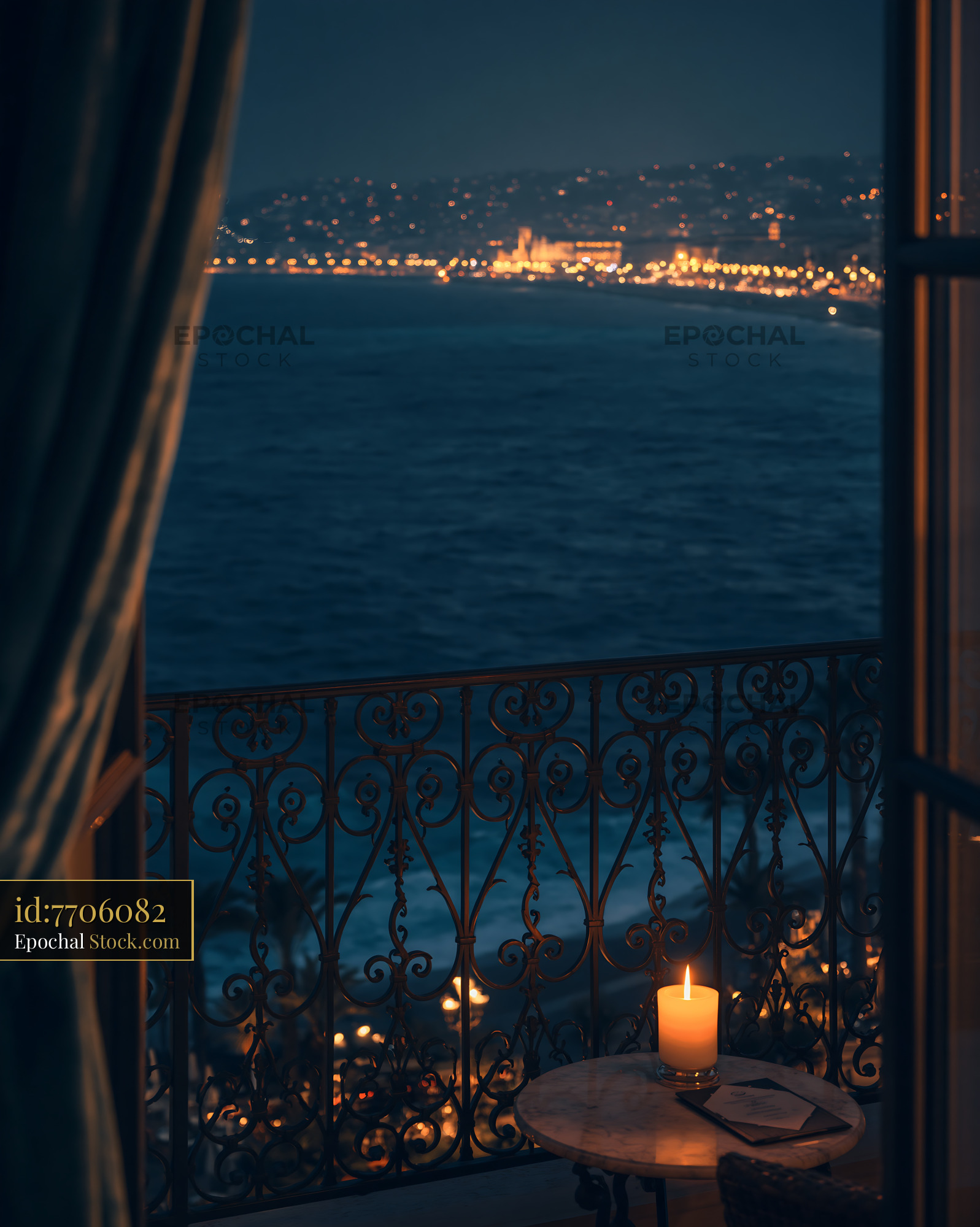 Burning candle on balcony overlooking coastal city at night - stock photo