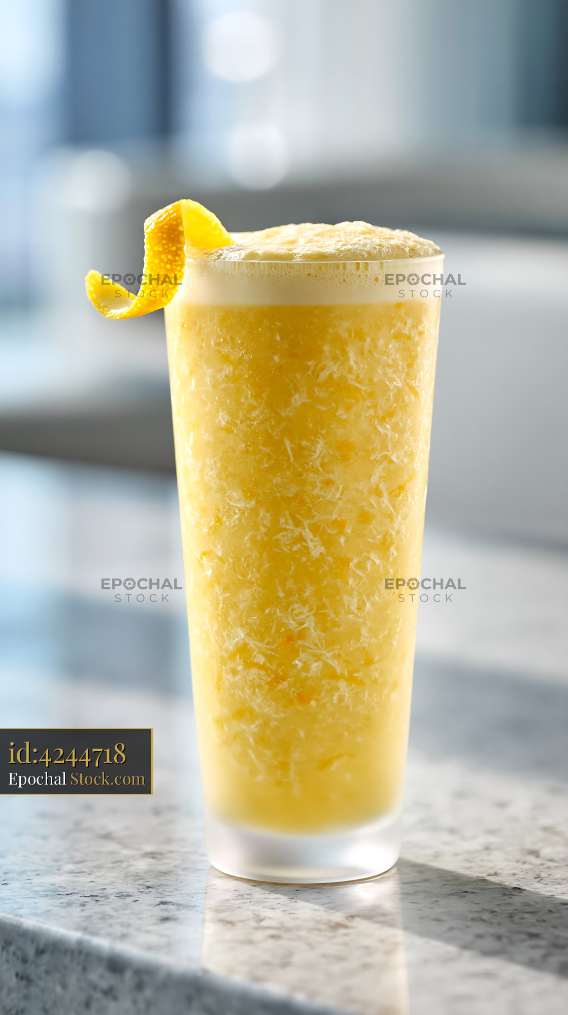 Fresh yuja citron smoothie with lemon twist on marble counter - stock photo