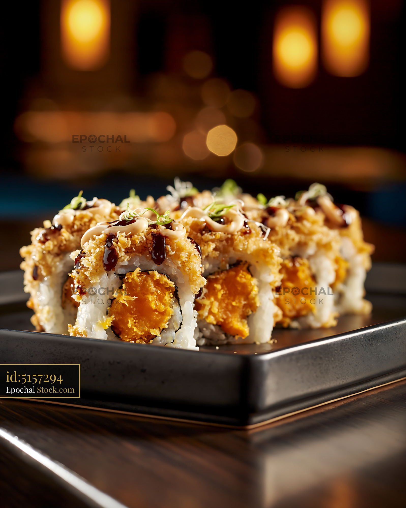 Sweet potato crunch sushi rolls on a black plate in a restaurant - stock photo