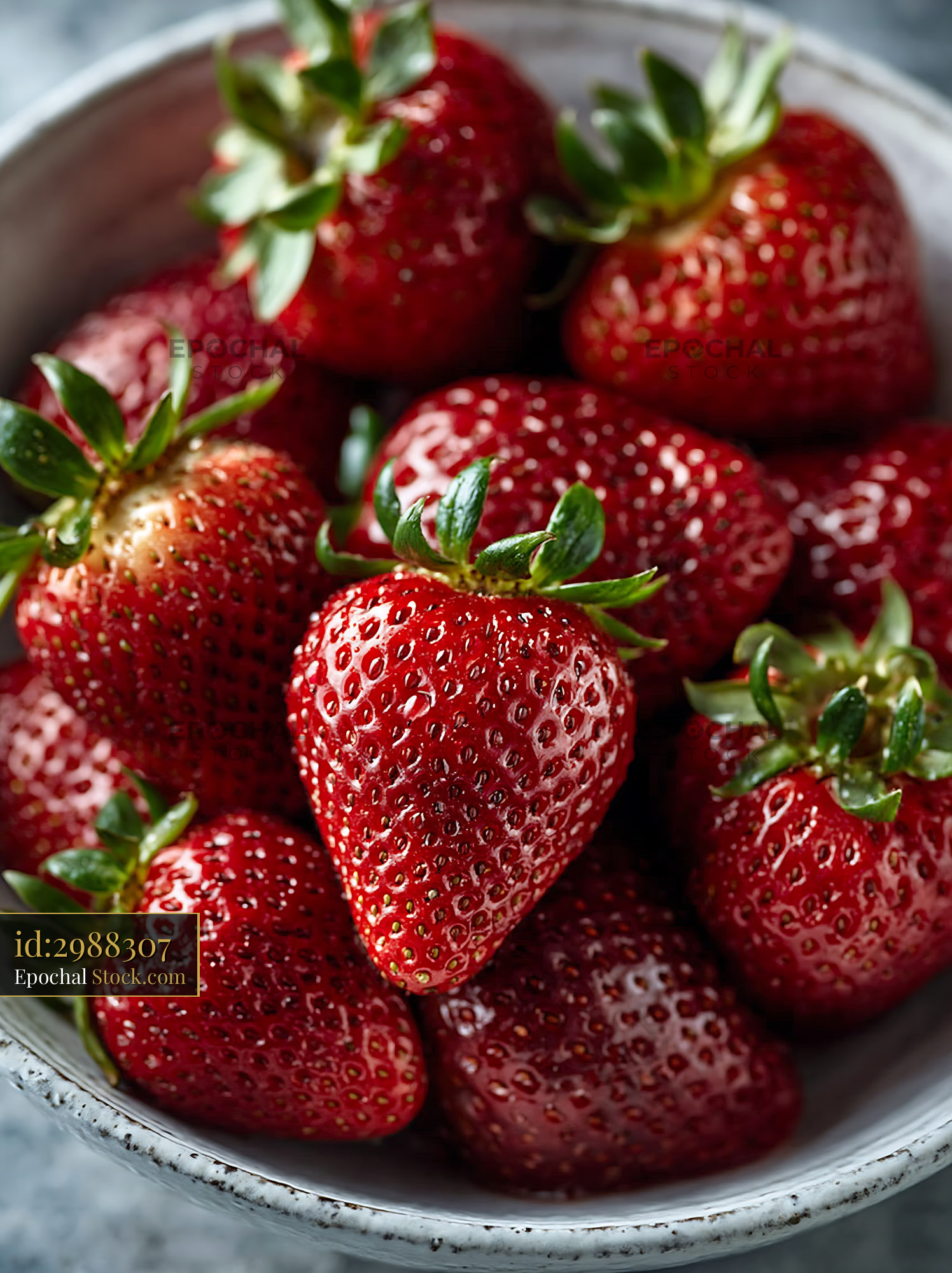 Fresh ripe strawberries with green leaves in a rustic ceramic bowl - stock photo