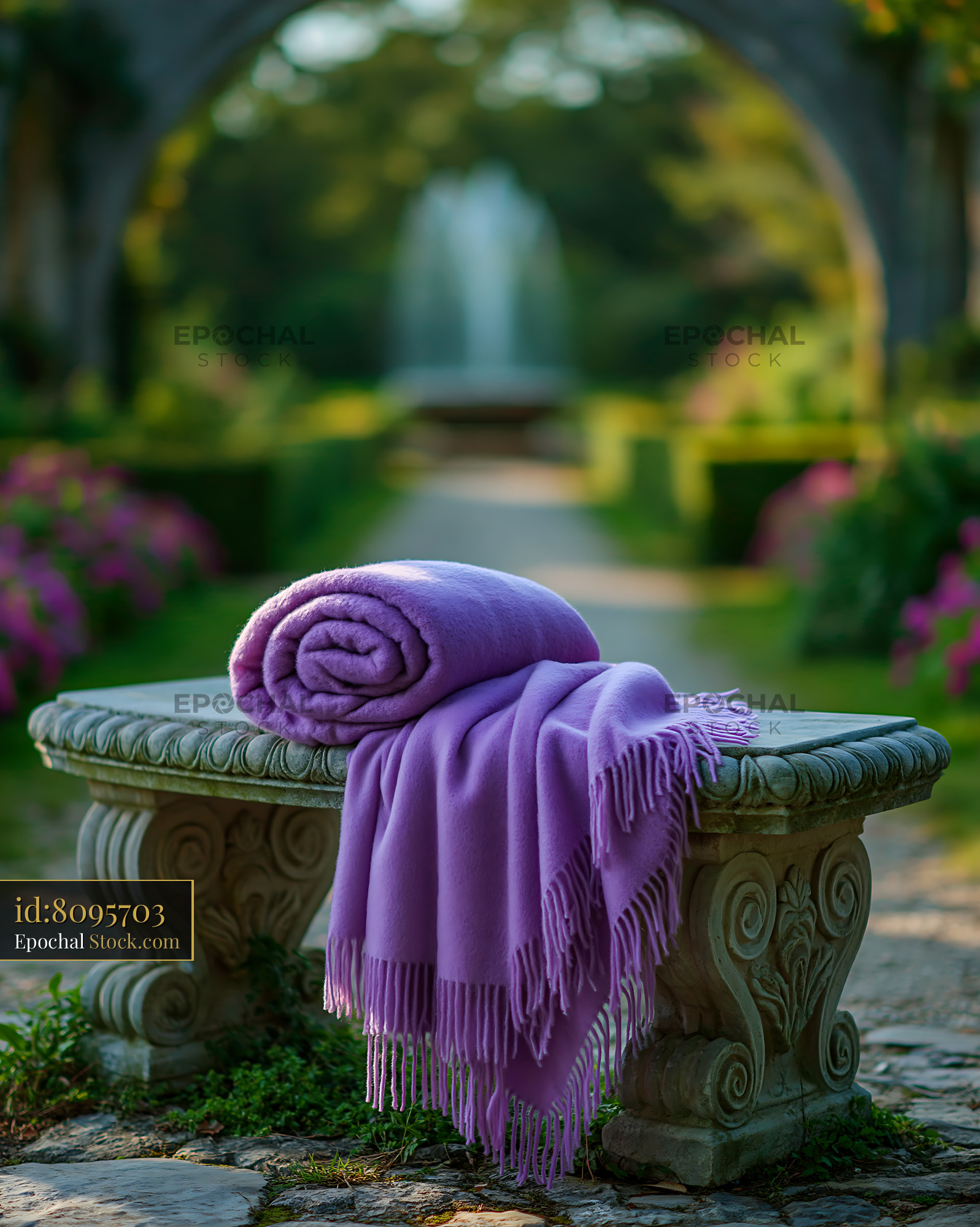 Purple wool blanket on an ornate stone bench in a lush garden - stock photo