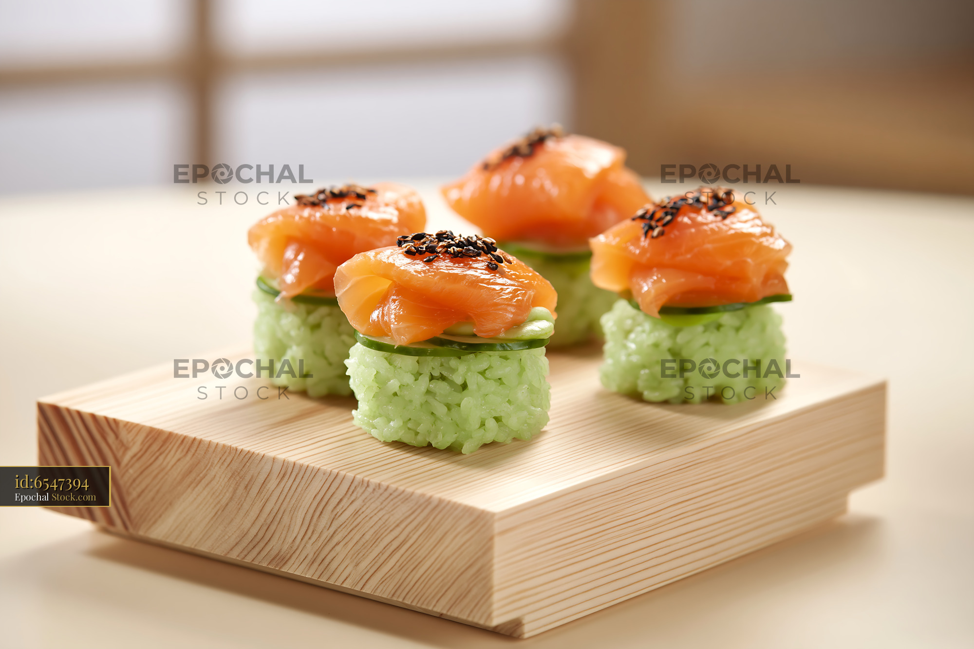 Salmon sushi with matcha infused rice and cucumber on wooden board - stock photo