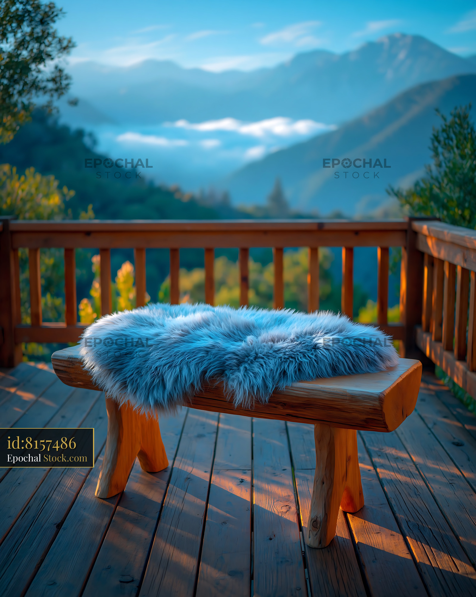 Rustic wooden bench with striped throw on mountain terrace at dawn - stock photo