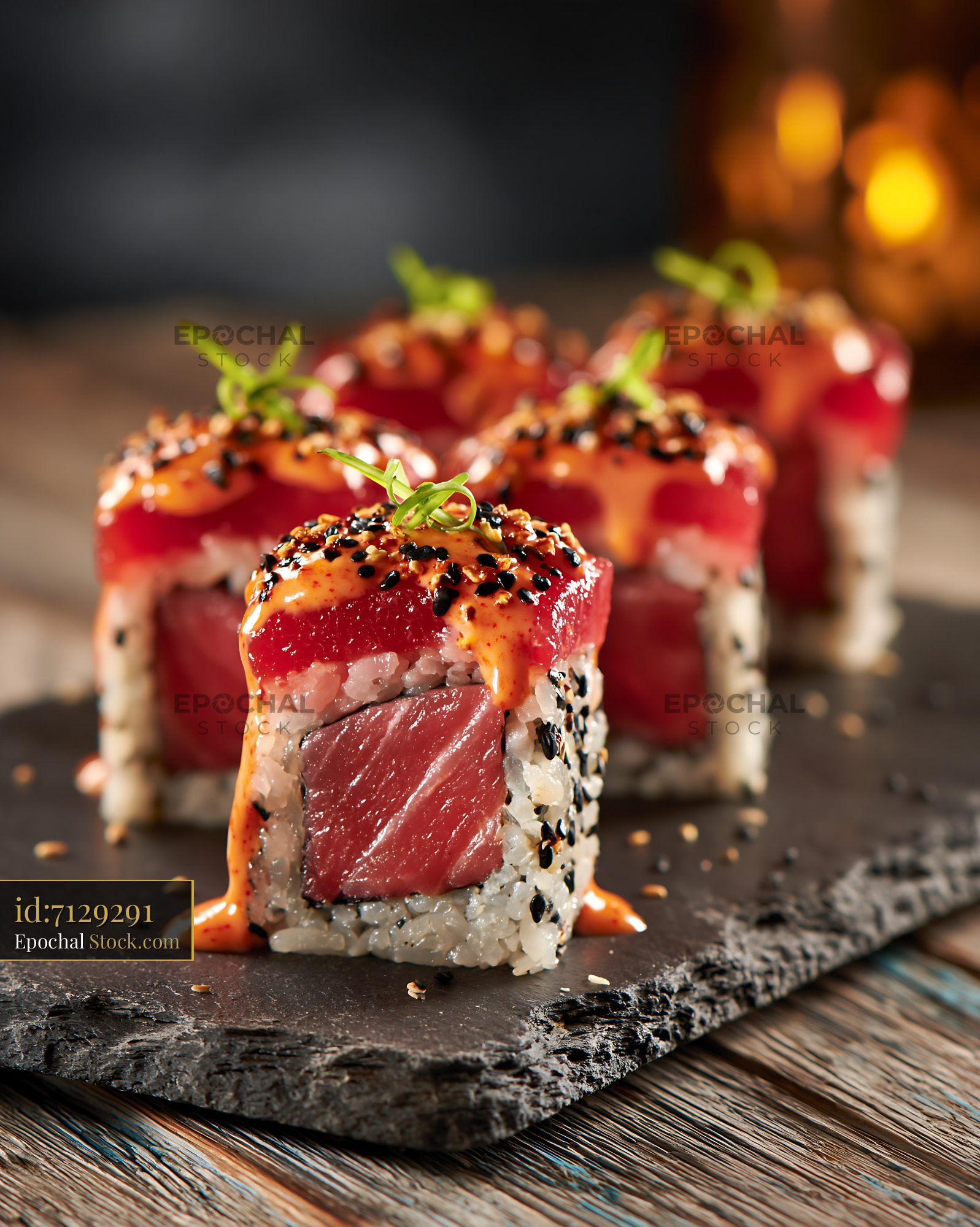 Sriracha mayo tuna sushi rolls on slate board in restaurant - stock photo