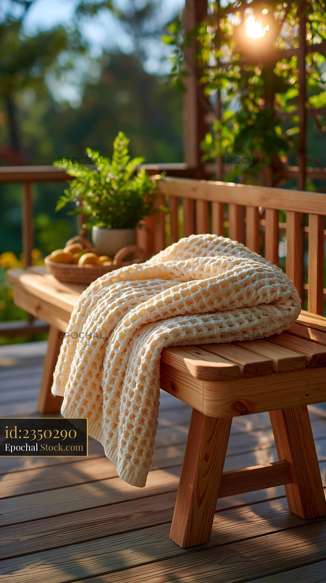 Cream striped throw on wooden bench during golden hour on a terrace - stock photo