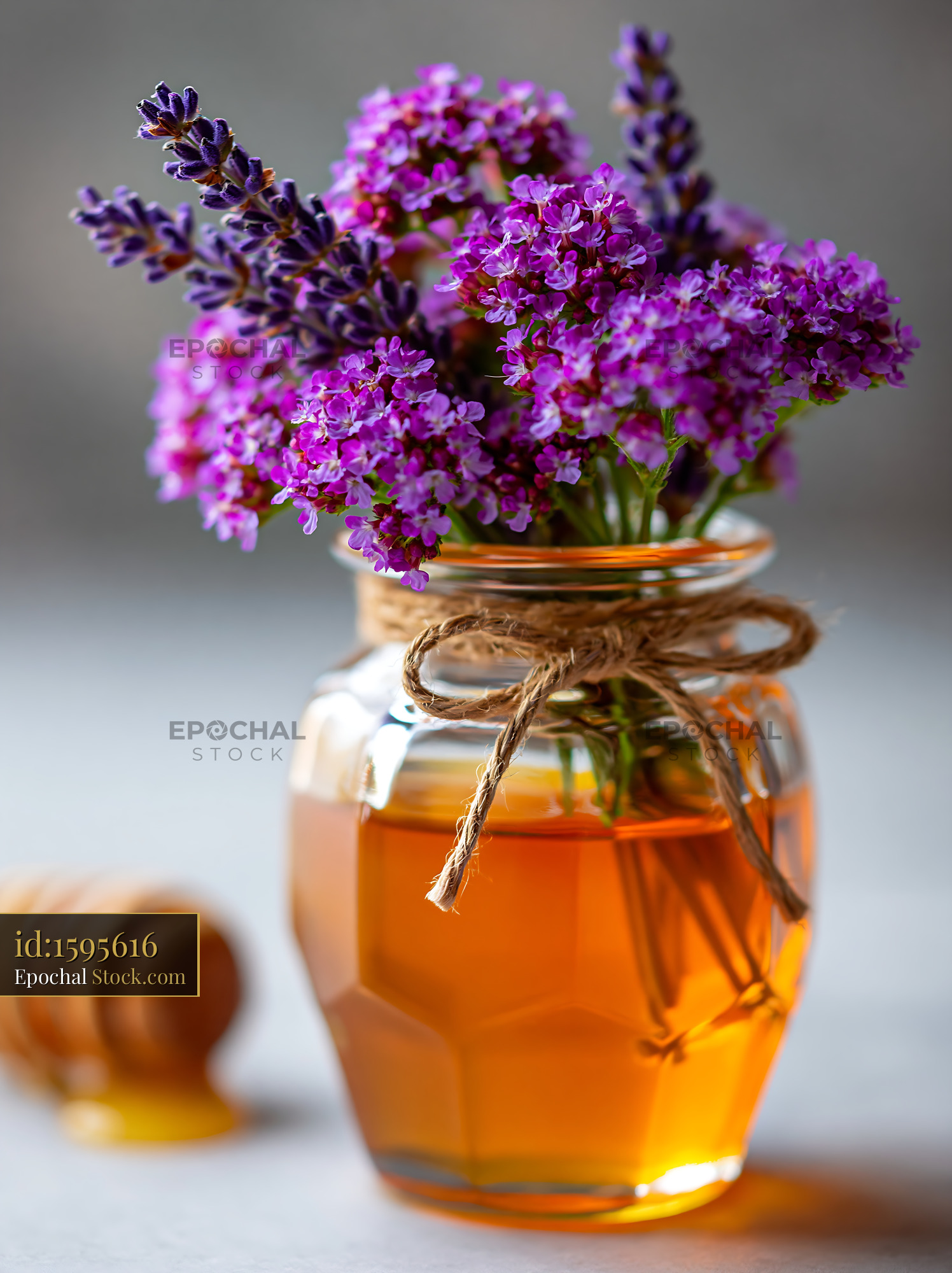 Artisanal honey jar with purple wildflowers and lavender bouquet - stock photo
