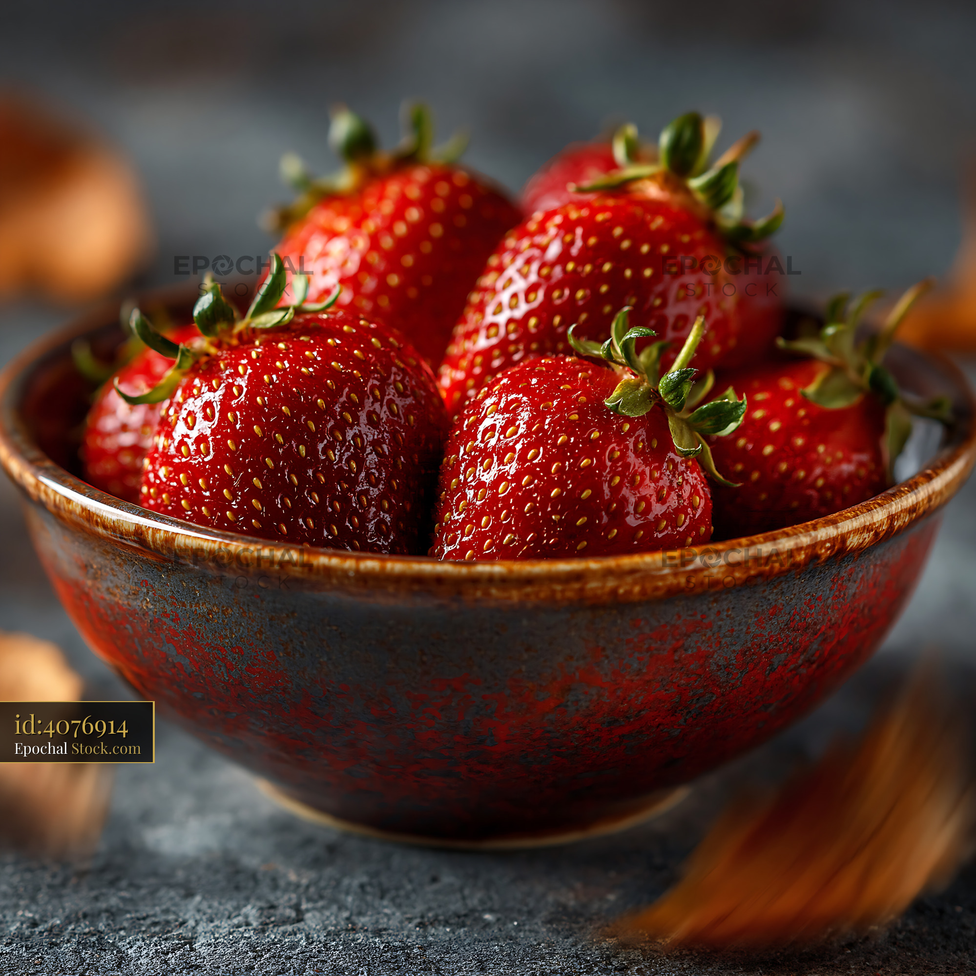 Fresh ripe strawberries in a rustic ceramic bowl on a dark surface - stock photo