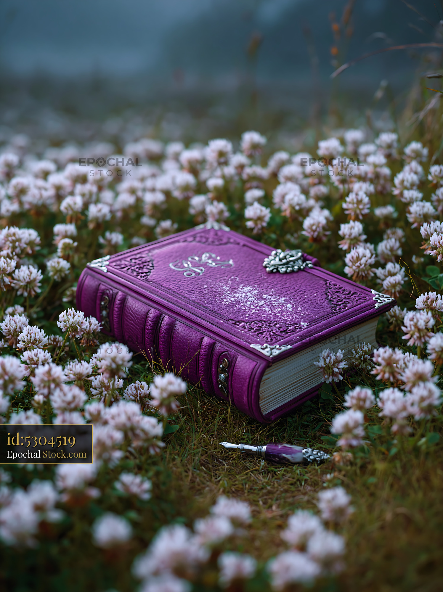 Ornate purple leather journal on a meadow floor among white clover - stock photo