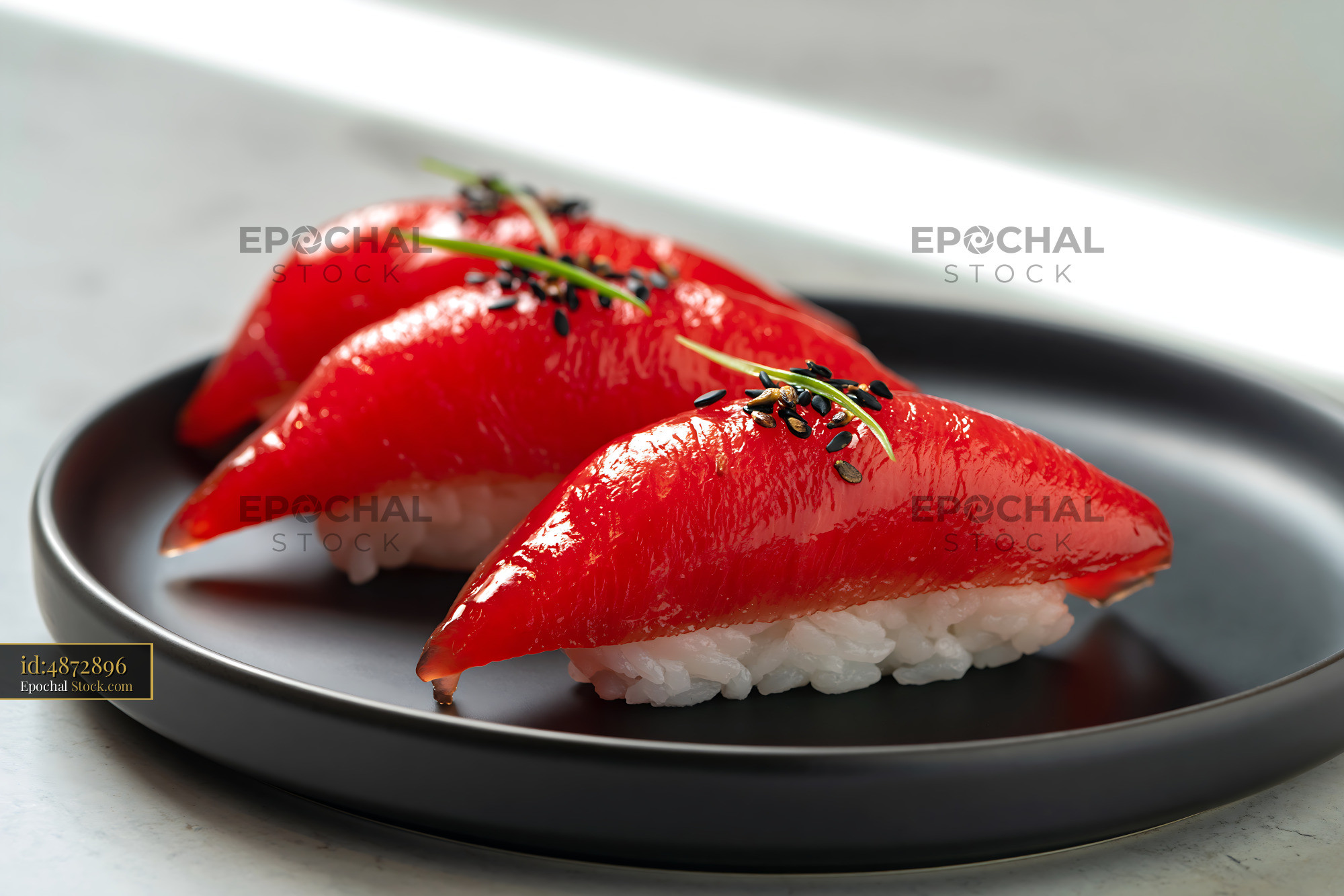 Vegan jackfruit nigiri sushi with sesame seeds on a black plate - stock photo