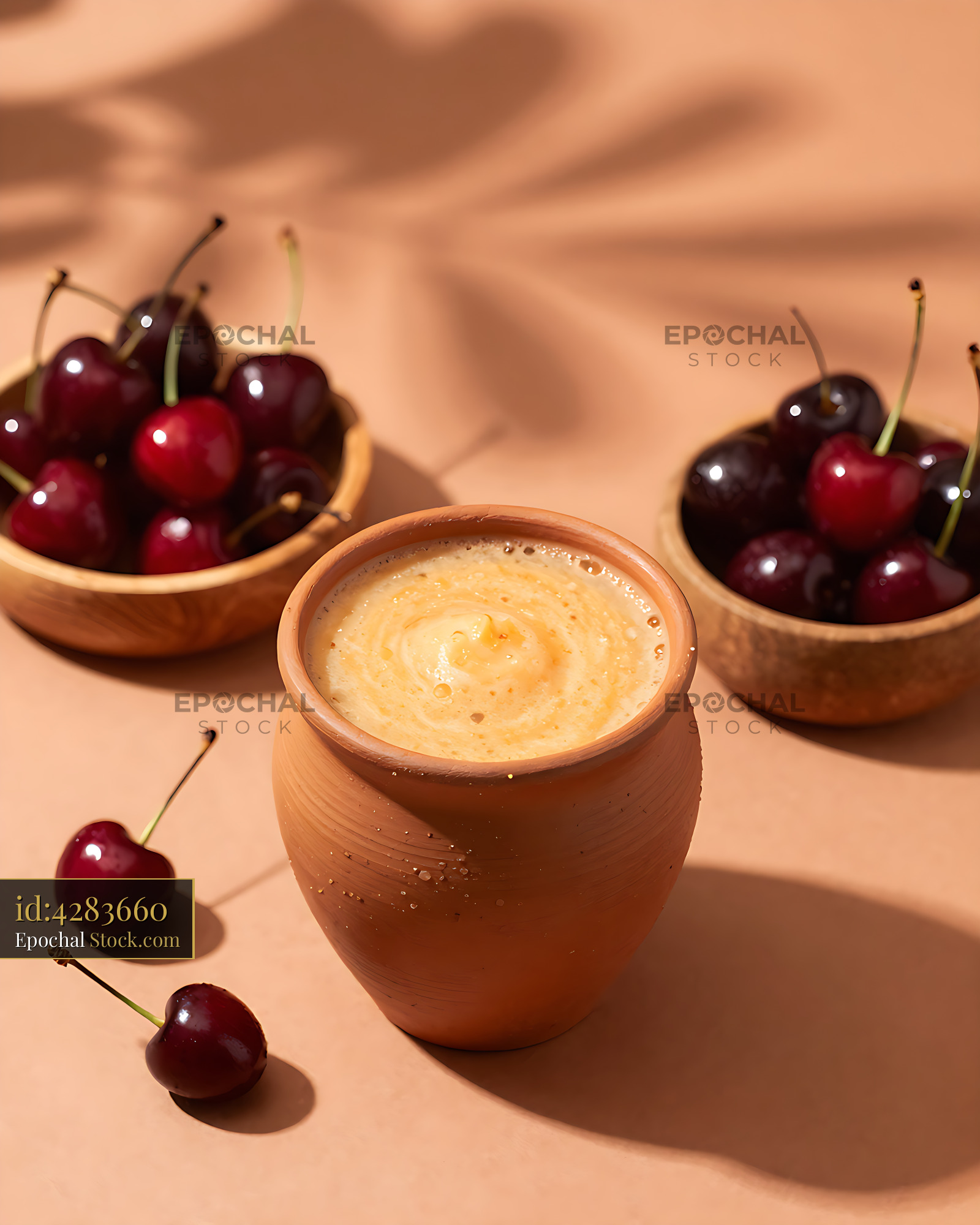 Fresh Acerola Sunrise smoothie in a terracotta cup with cherries - stock photo