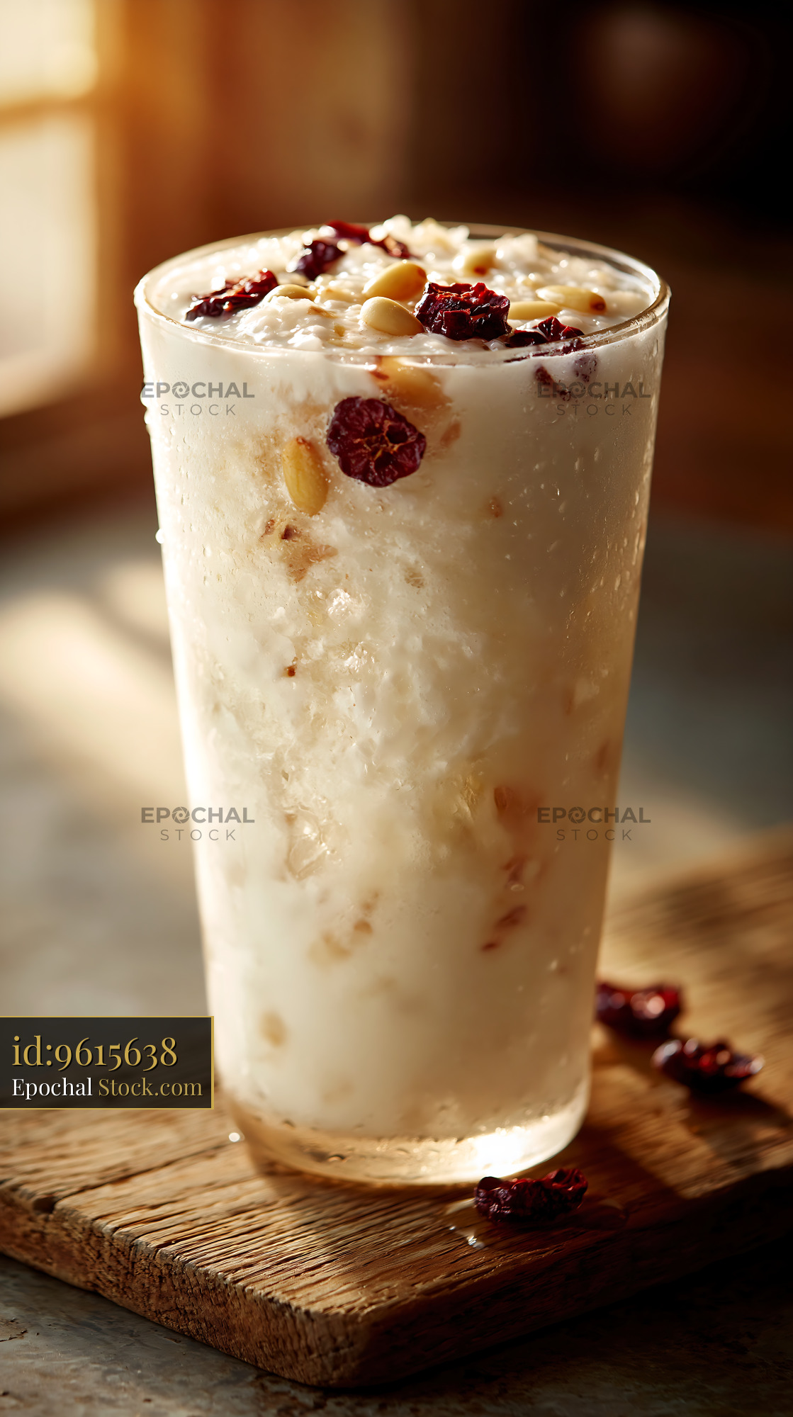 Sikhye rice smoothie with pine nuts and cranberries in golden light - stock photo
