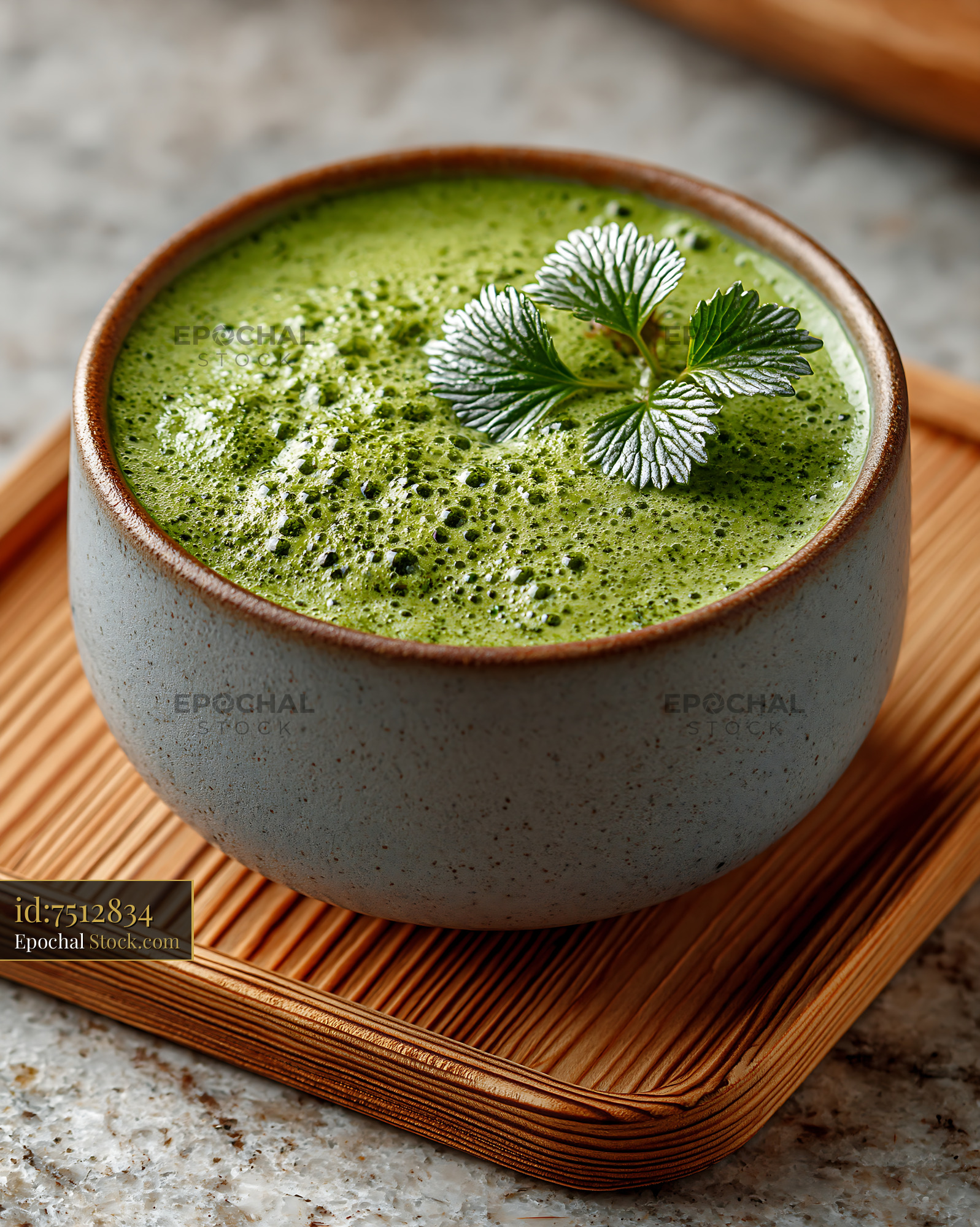 Frothy mugwort herb smoothie in a ceramic bowl on a bamboo tray - stock photo