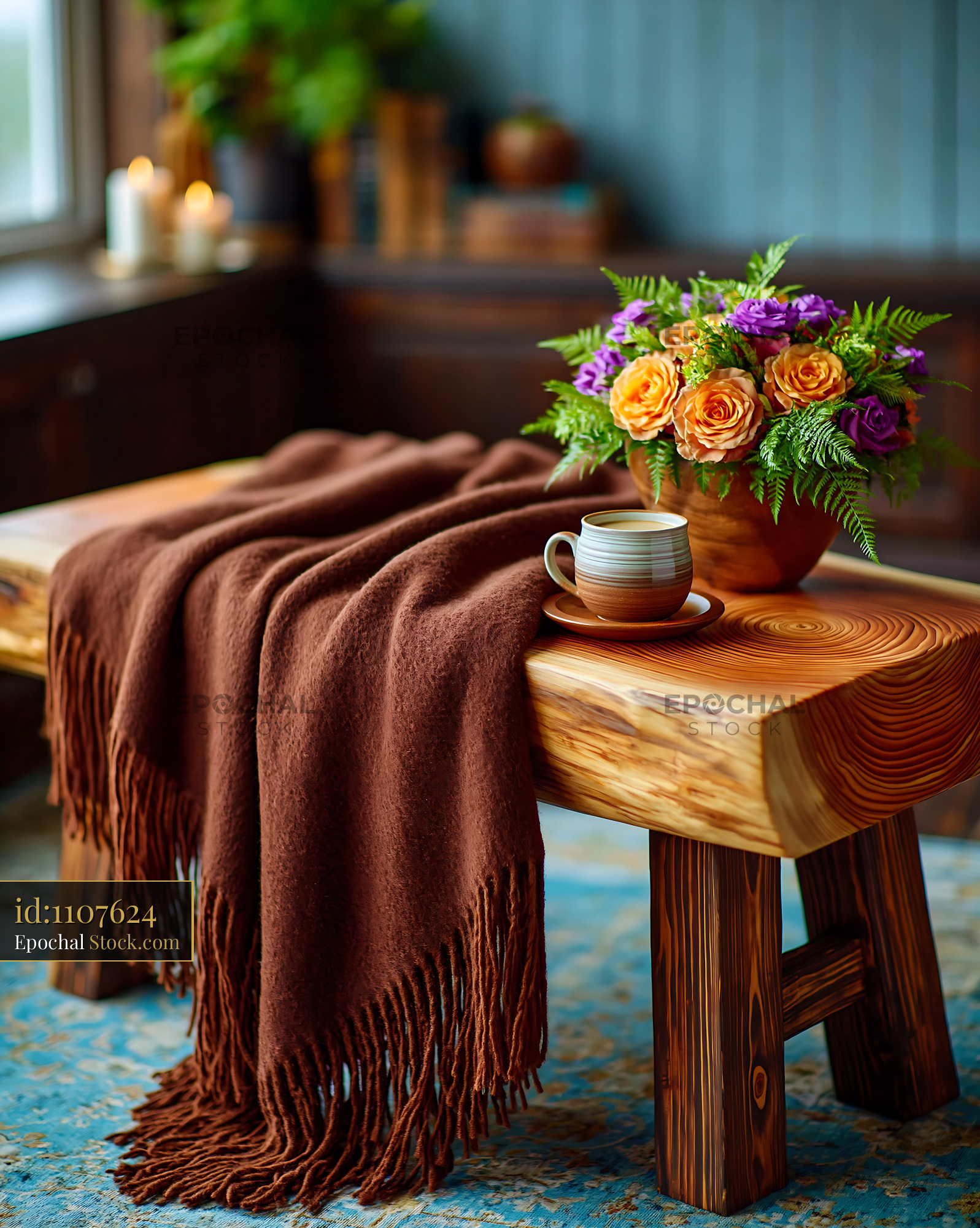 Cashmere throw on bench with coffee and flowers in cozy room - stock photo