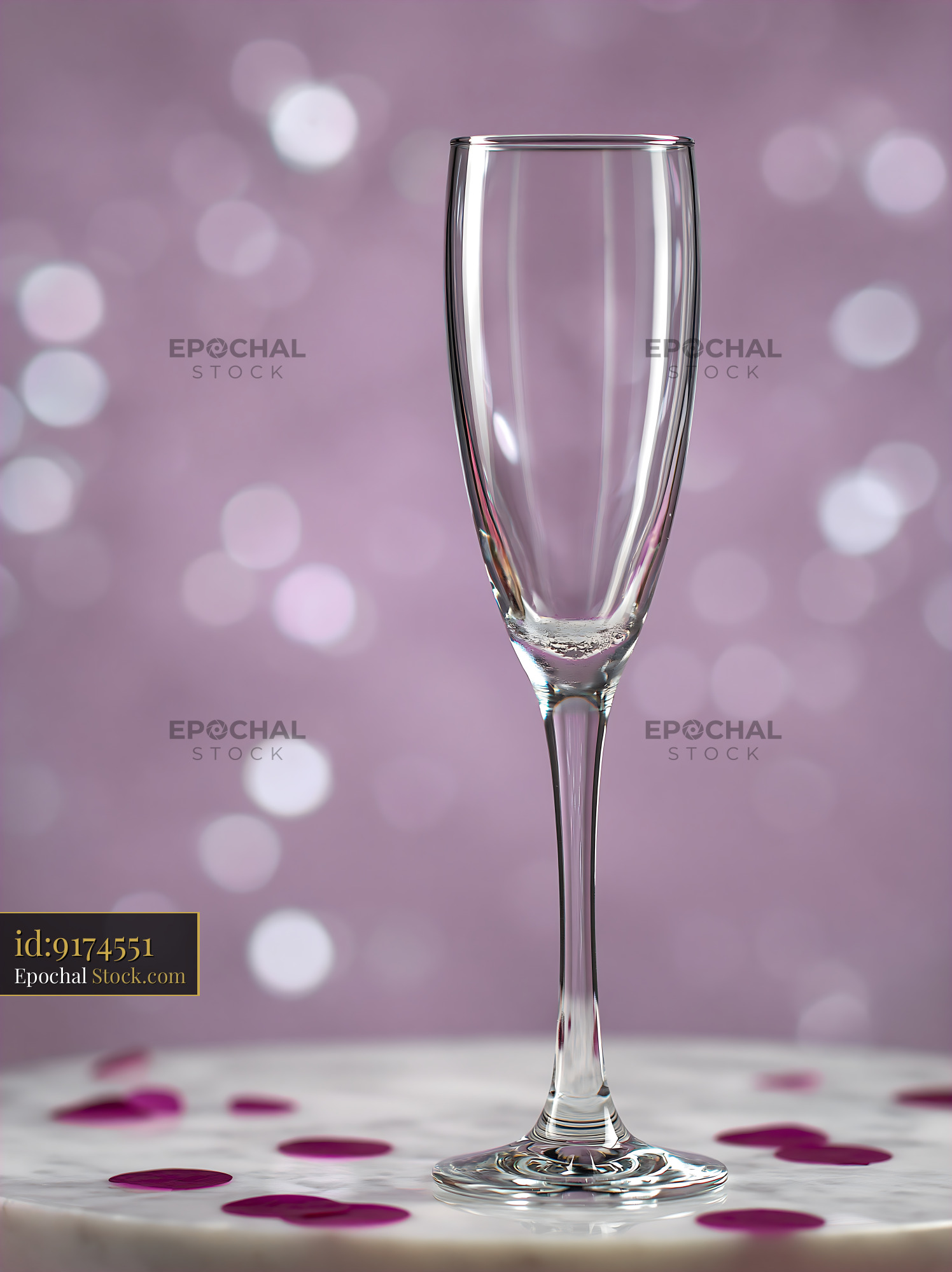 Empty champagne glass on marble table with purple bokeh background - stock photo