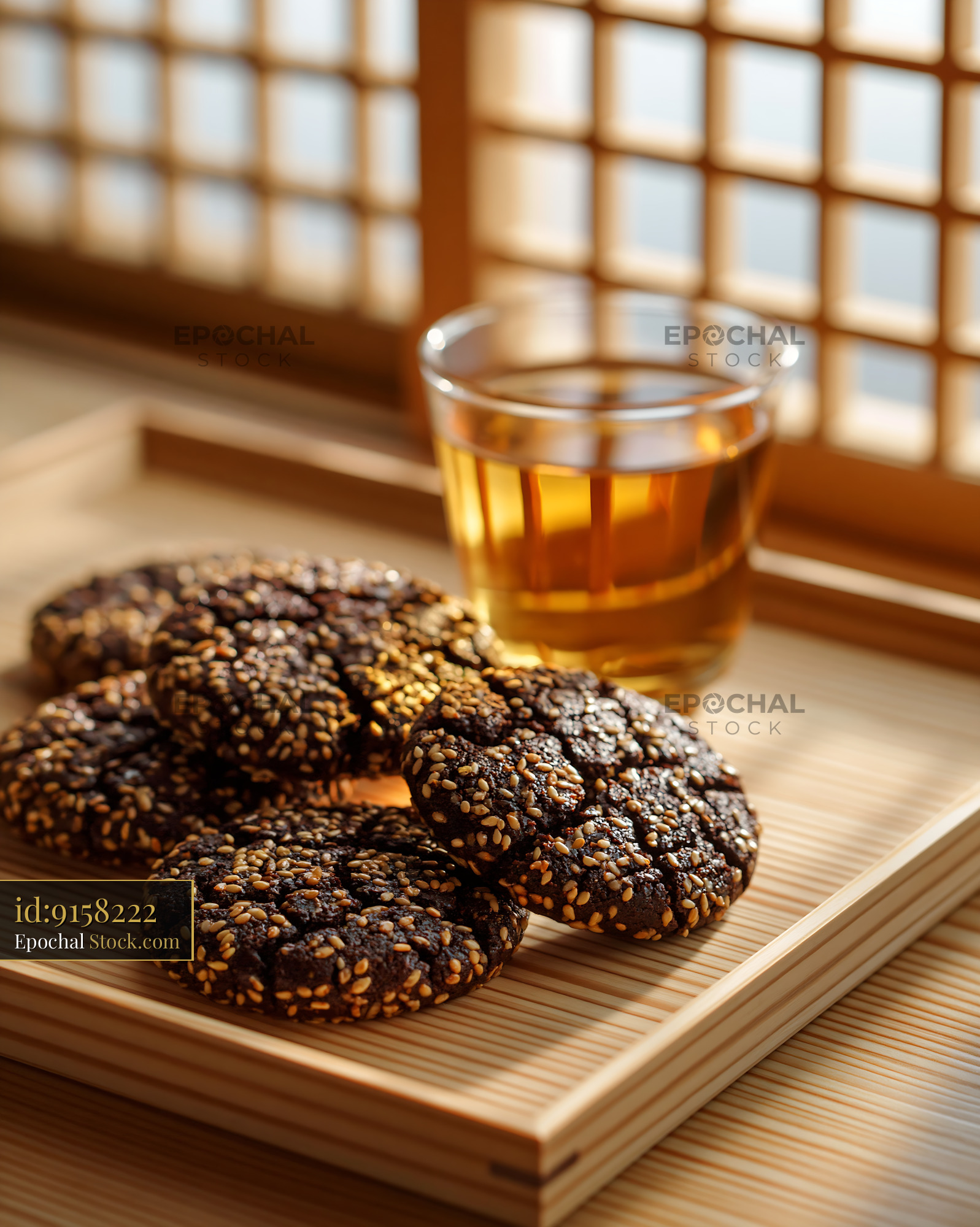 Dibs el kharroub biscuits with sesame seeds and tea on a wooden tray - stock photo