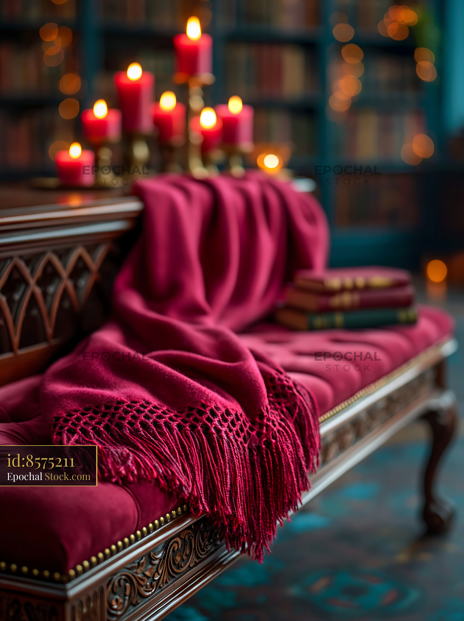 Red cashmere throw on velvet bench in a cozy candlelit library - stock photo