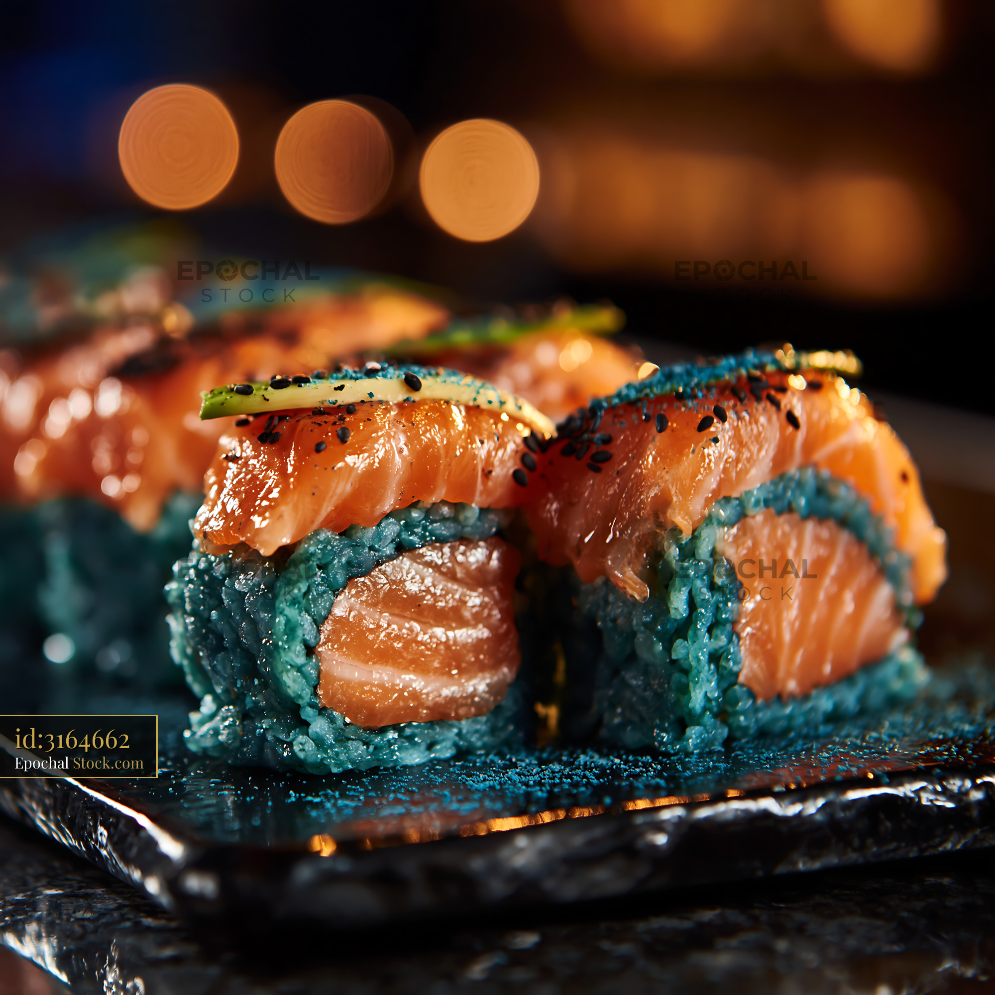 Salmon sushi rolls with blue spirulina rice served on slate plate - stock photo