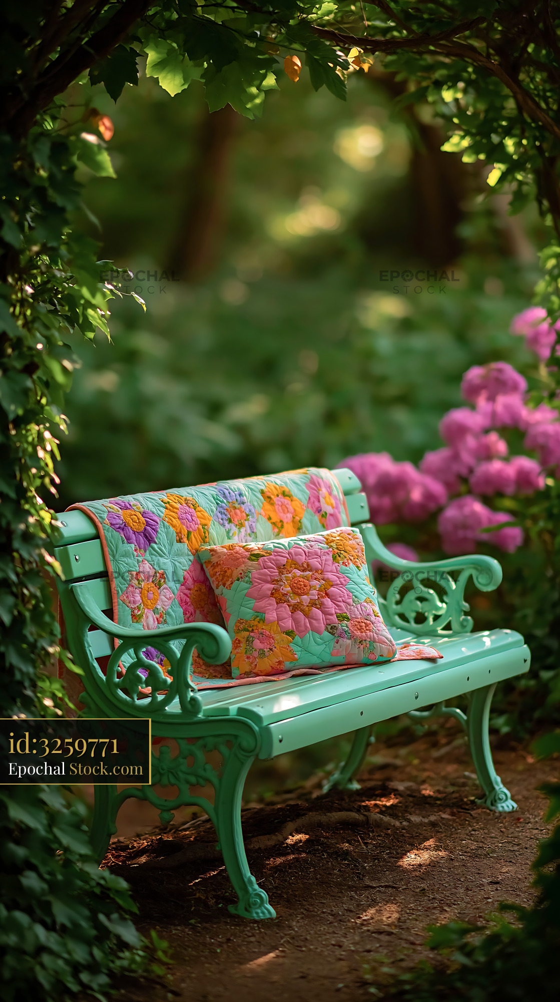 Ornate garden bench with colorful quilt and pillow under leafy arch - stock photo