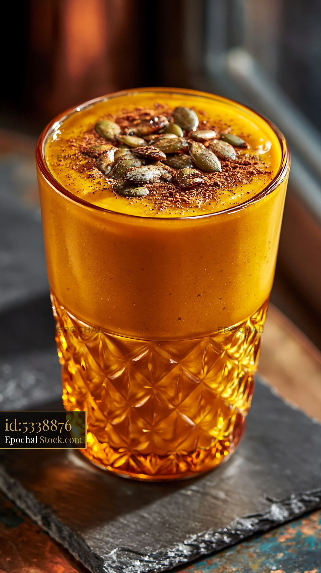 Kabocha pumpkin smoothie with seeds in a decorative amber glass - stock photo