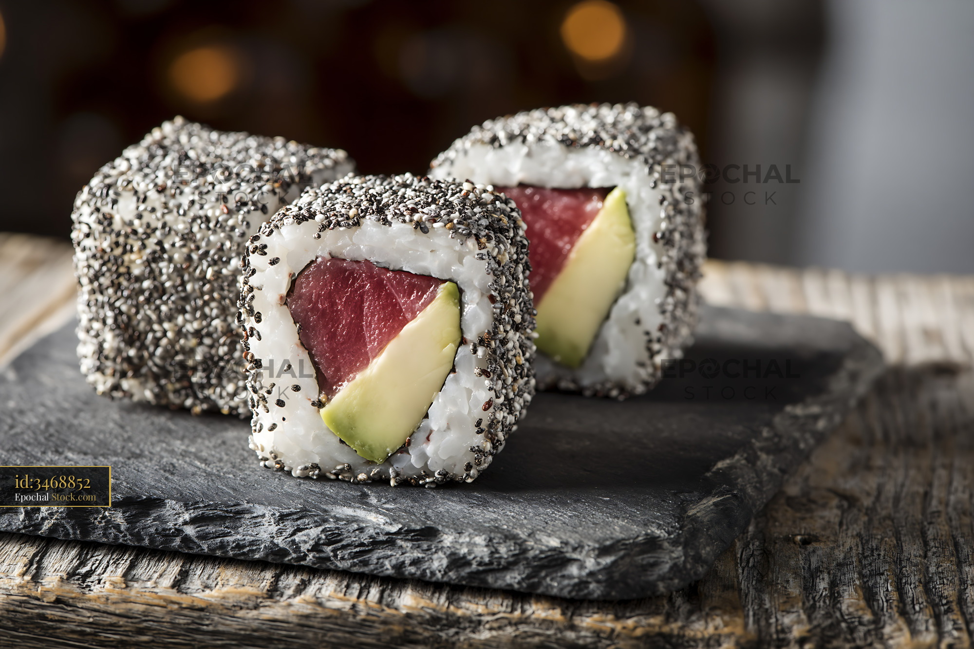 Tuna and avocado sushi rolls with a chia seed crust on slate - stock photo