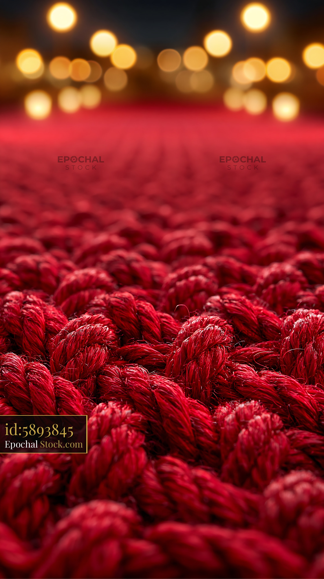 Red knotted rope on an empty stage with warm bokeh lights - stock photo