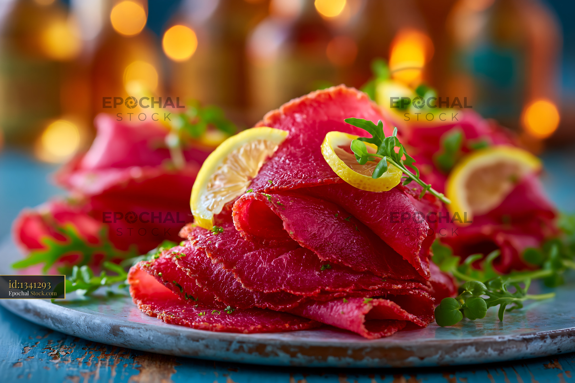 Bresaola della Valtellina meat slices with lemon and fresh microgreens - stock photo