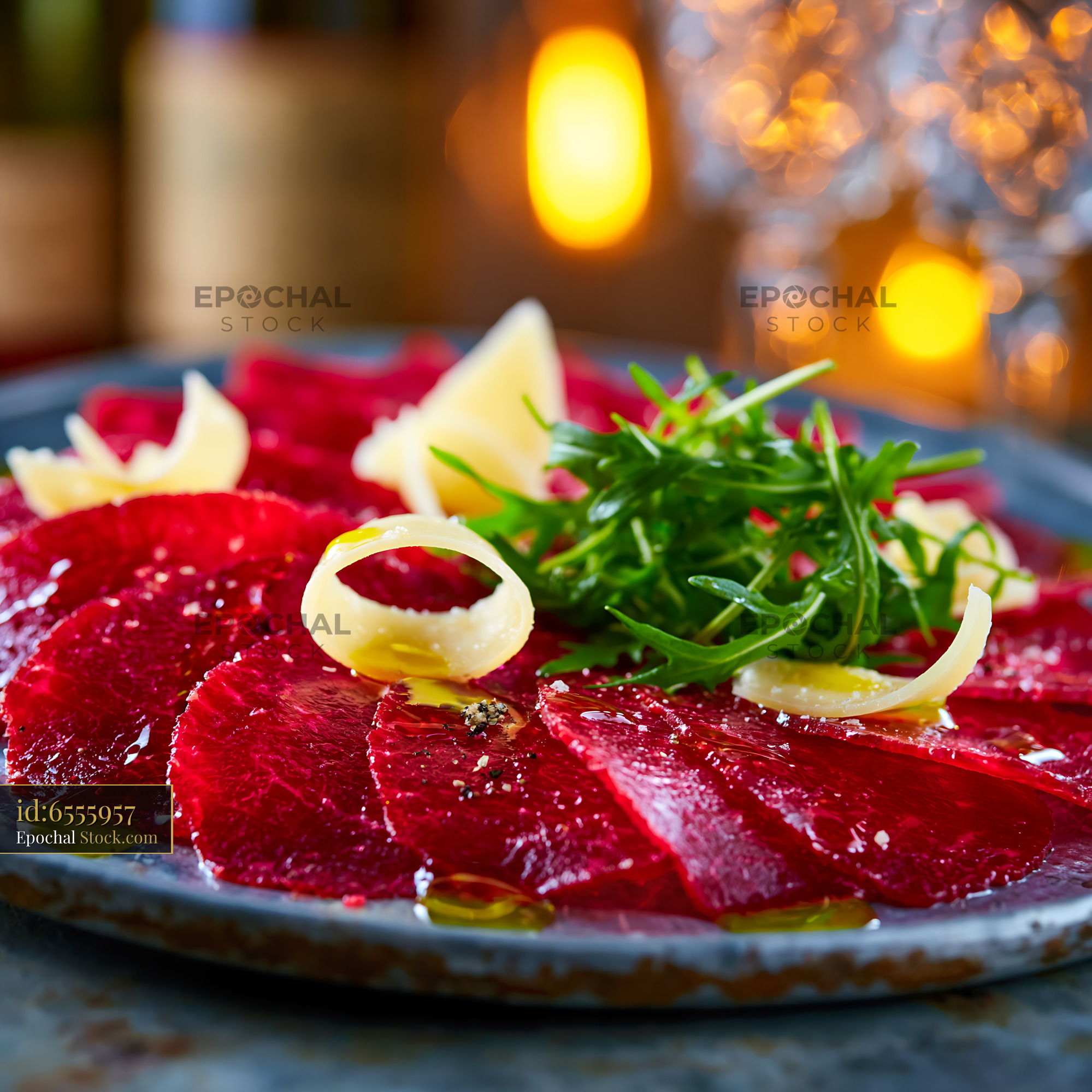 Thinly sliced bresaola della valtellina meat with parmesan and arugula - stock photo