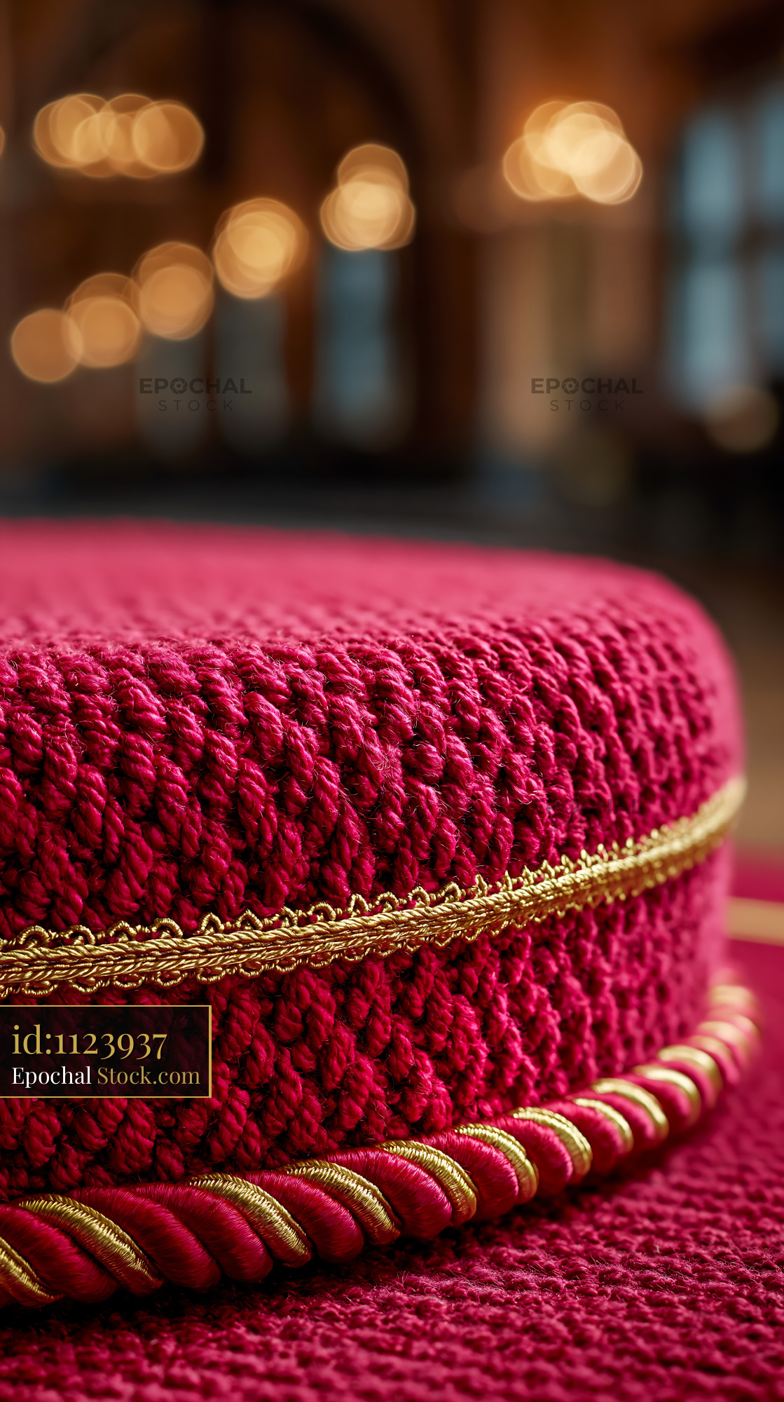 Close up of a red woven ottoman with gold trim in a luxury hotel lobby - stock photo