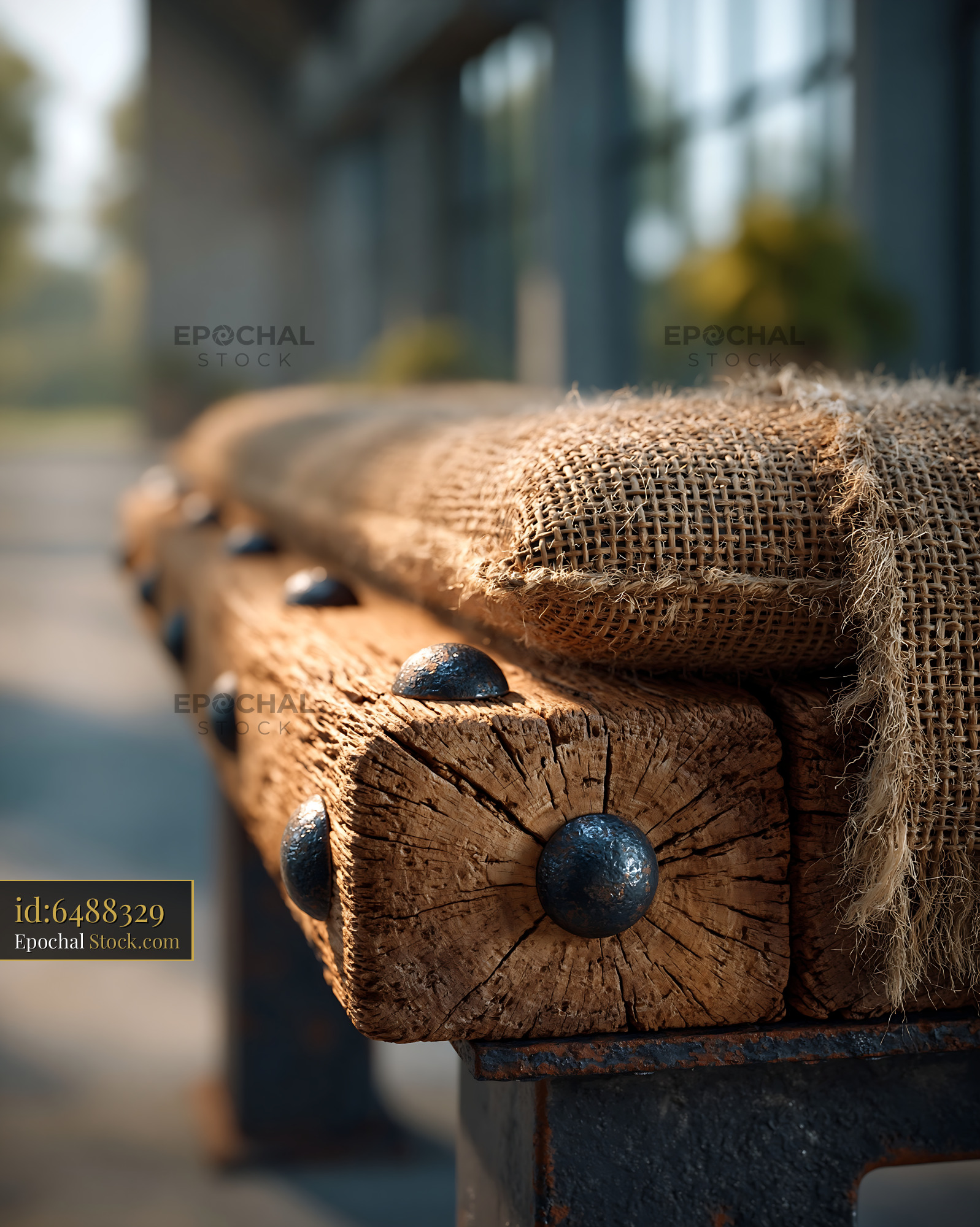 Rustic seating with throw on weathered wooden beams with metal rivets - stock photo