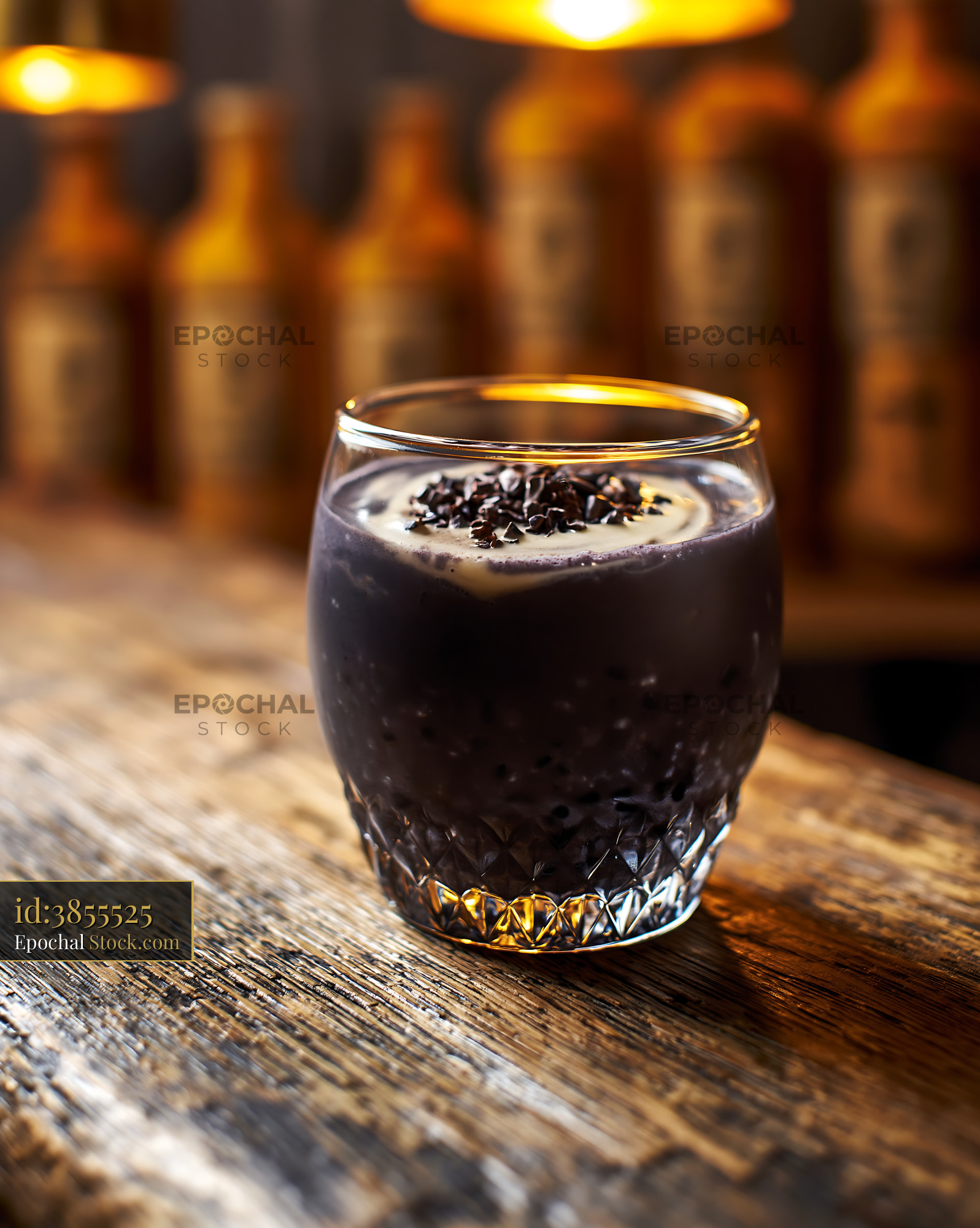 Healthy black bean smoothie with creamy topping on a rustic table - stock photo