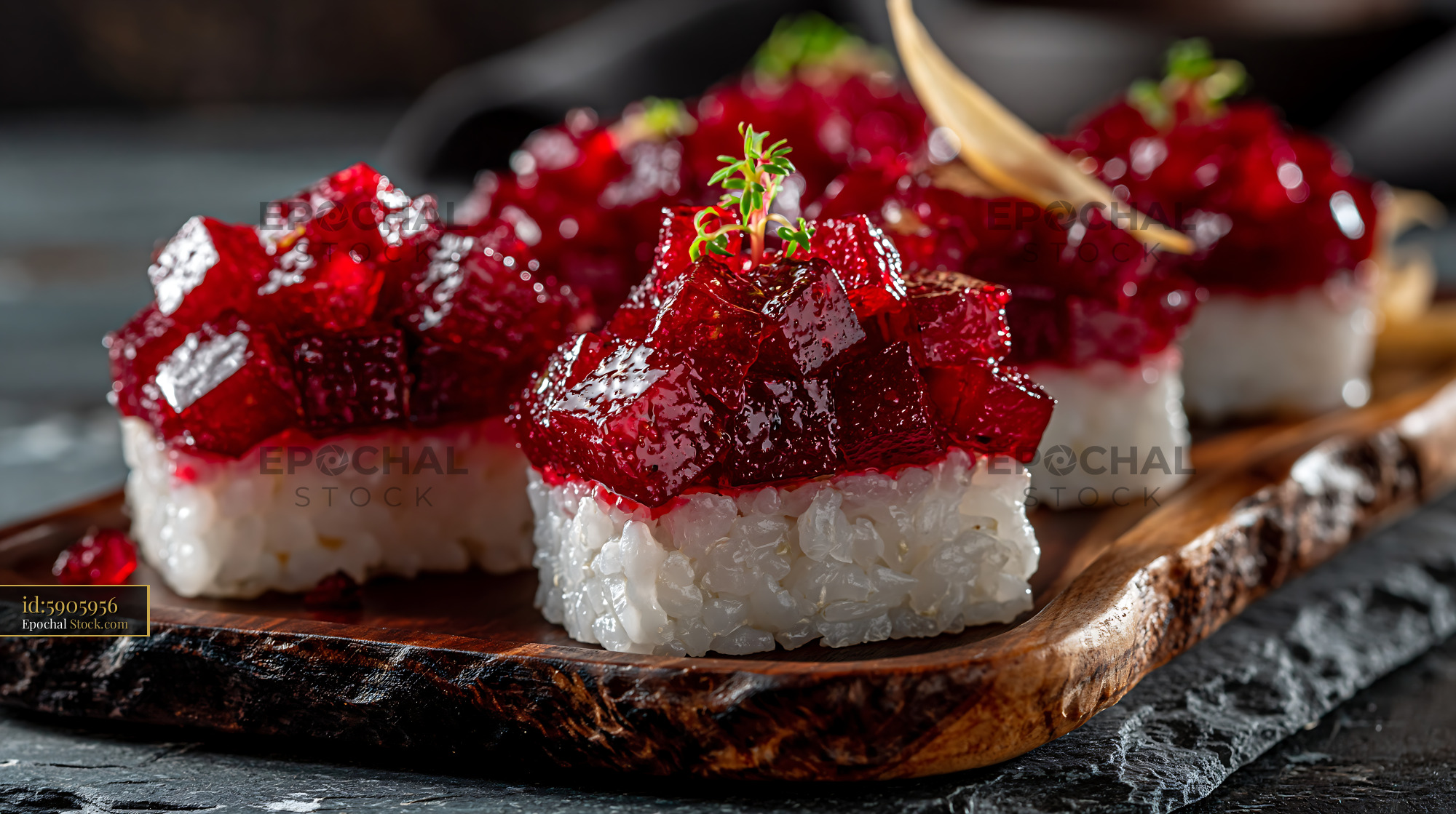 Gourmet beet tartare sushi pieces served on a dark wooden platter - stock photo