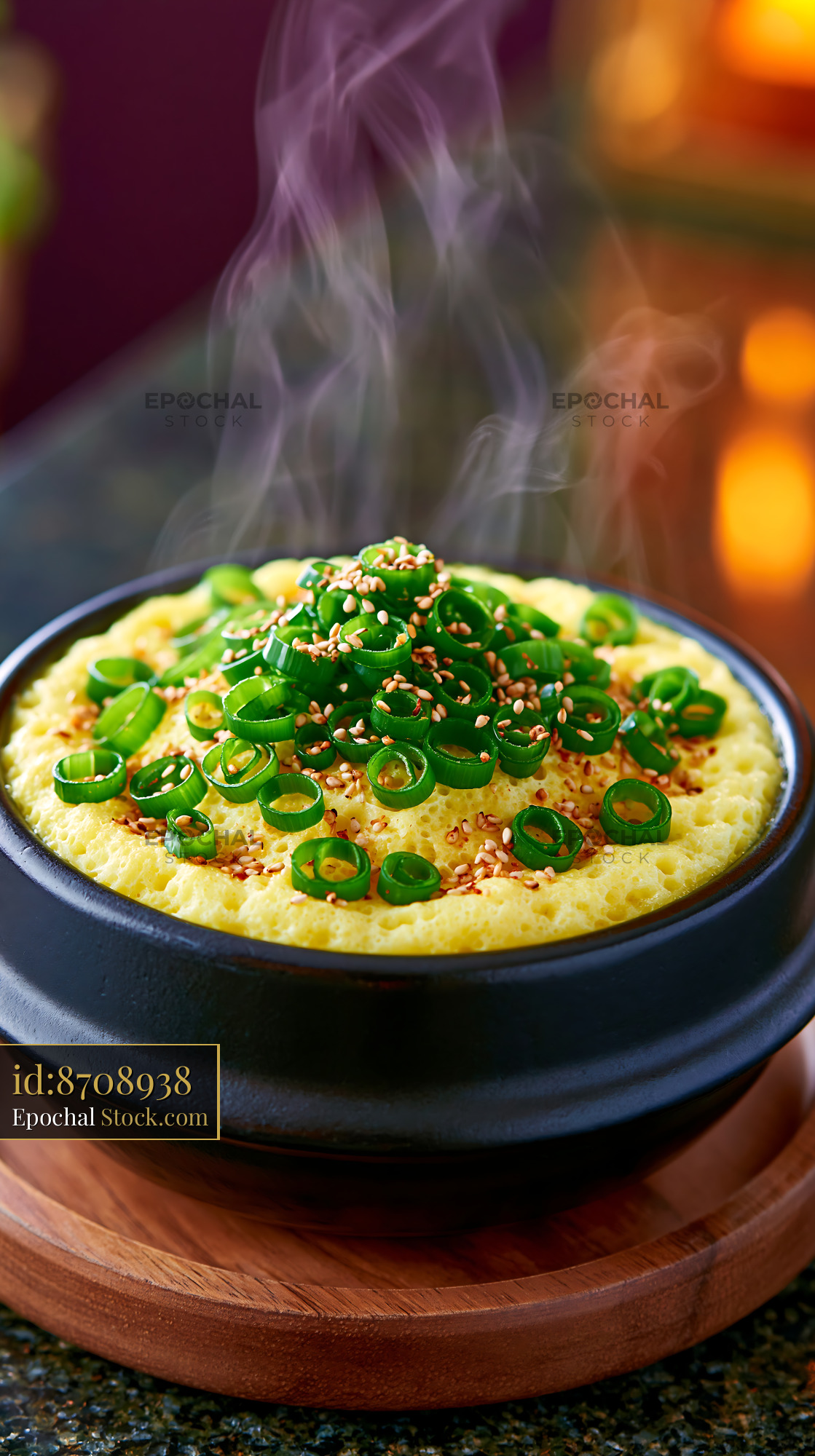 Steaming Korean steamed egg gyeran-jjim in a black earthenware bowl - stock photo