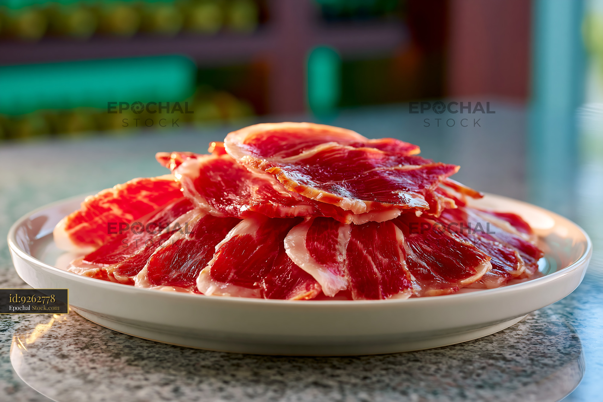 Sliced jamon iberico de bellota meat served on a white plate - stock photo