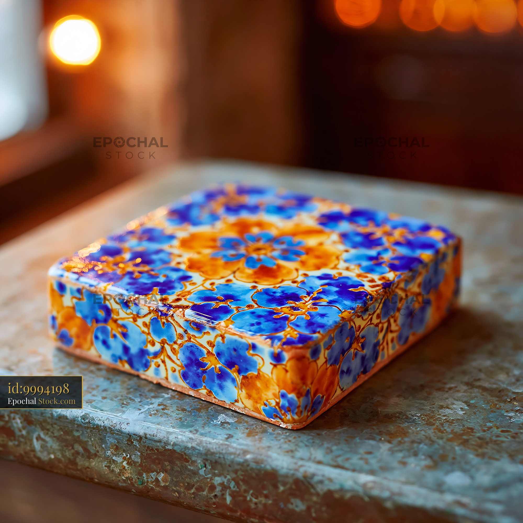 Handcrafted ceramic tile with blue and orange floral patterns - stock photo