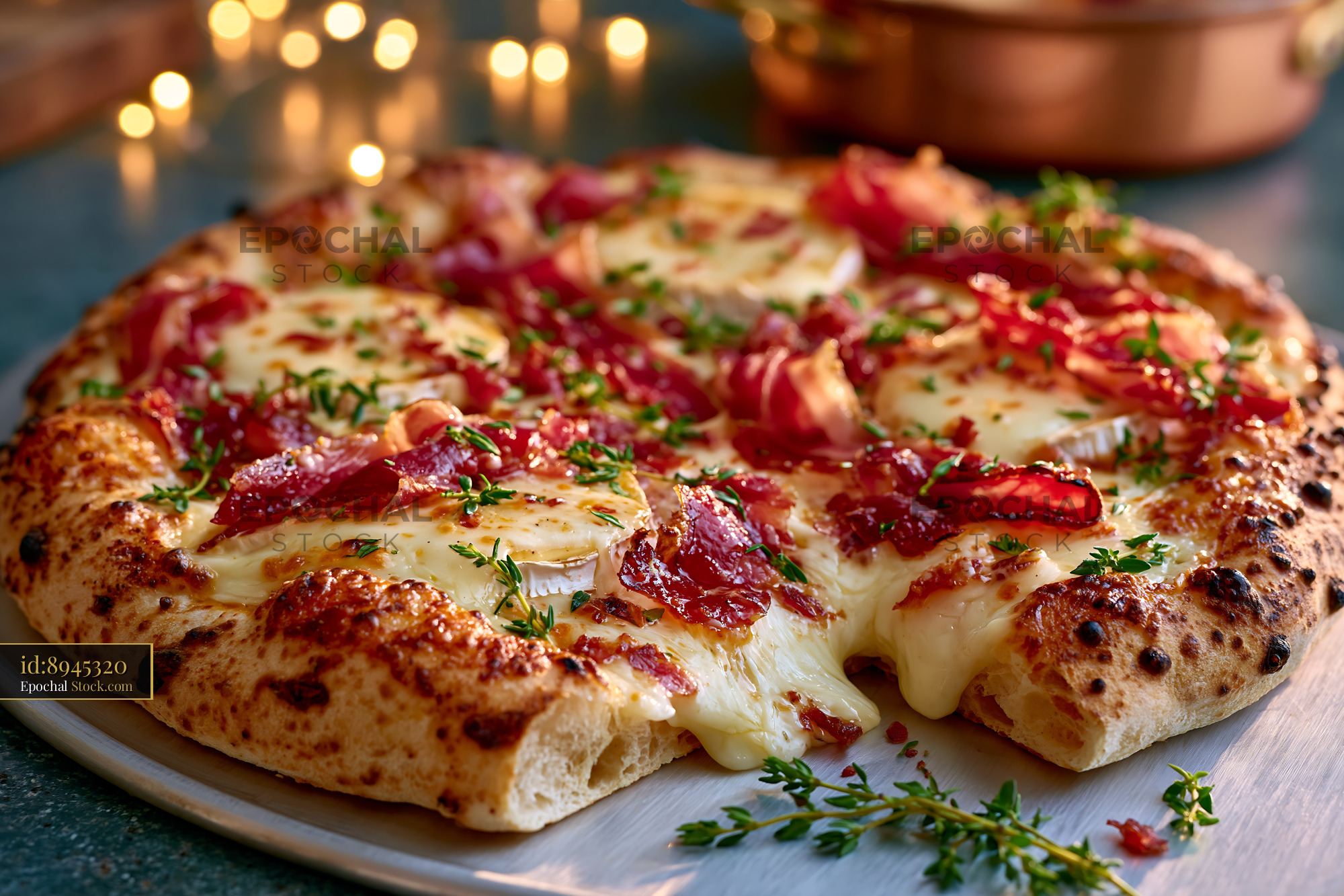 Artisanal speck brie pizza with melted cheese and fresh thyme herbs - stock photo