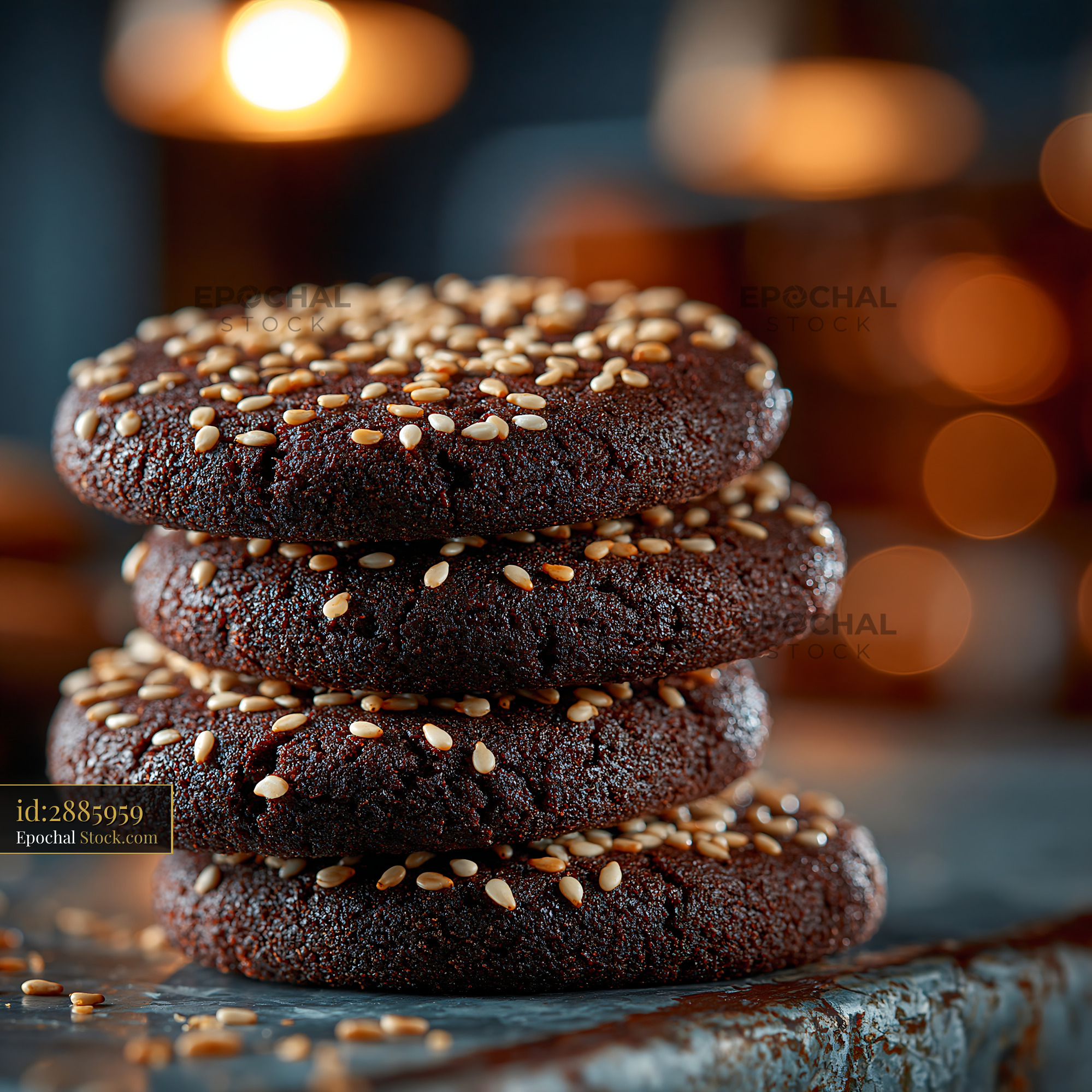 Stack of dark dibs el kharroub biscuits topped with sesame seeds - stock photo