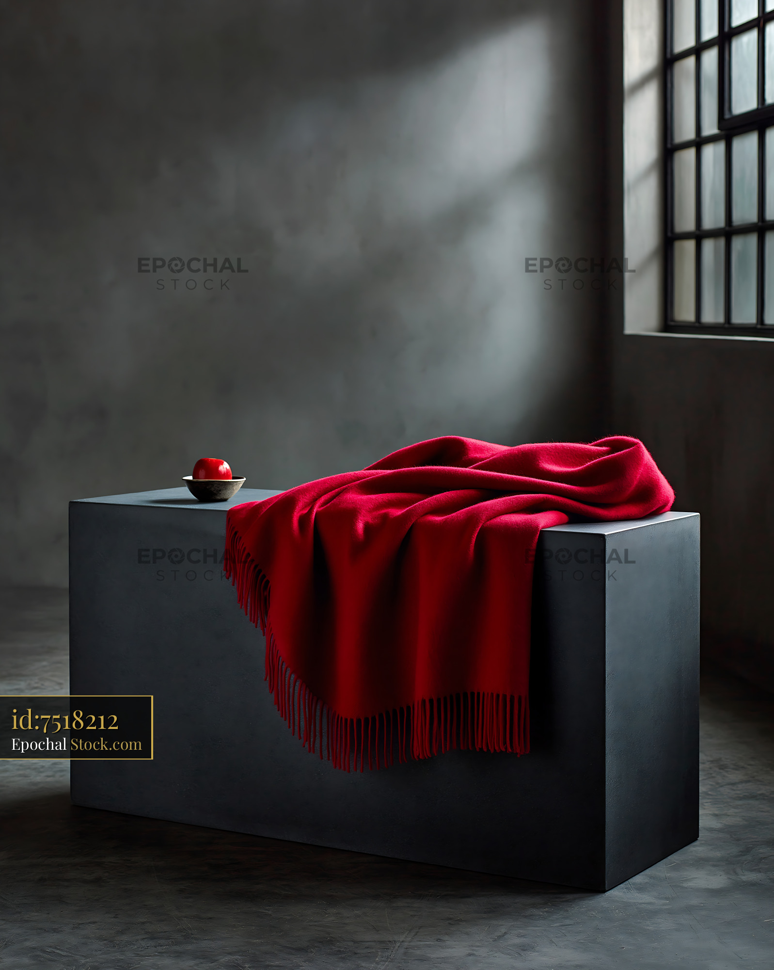 Red wool throw blanket on a minimalist concrete bench in a moody room - stock photo