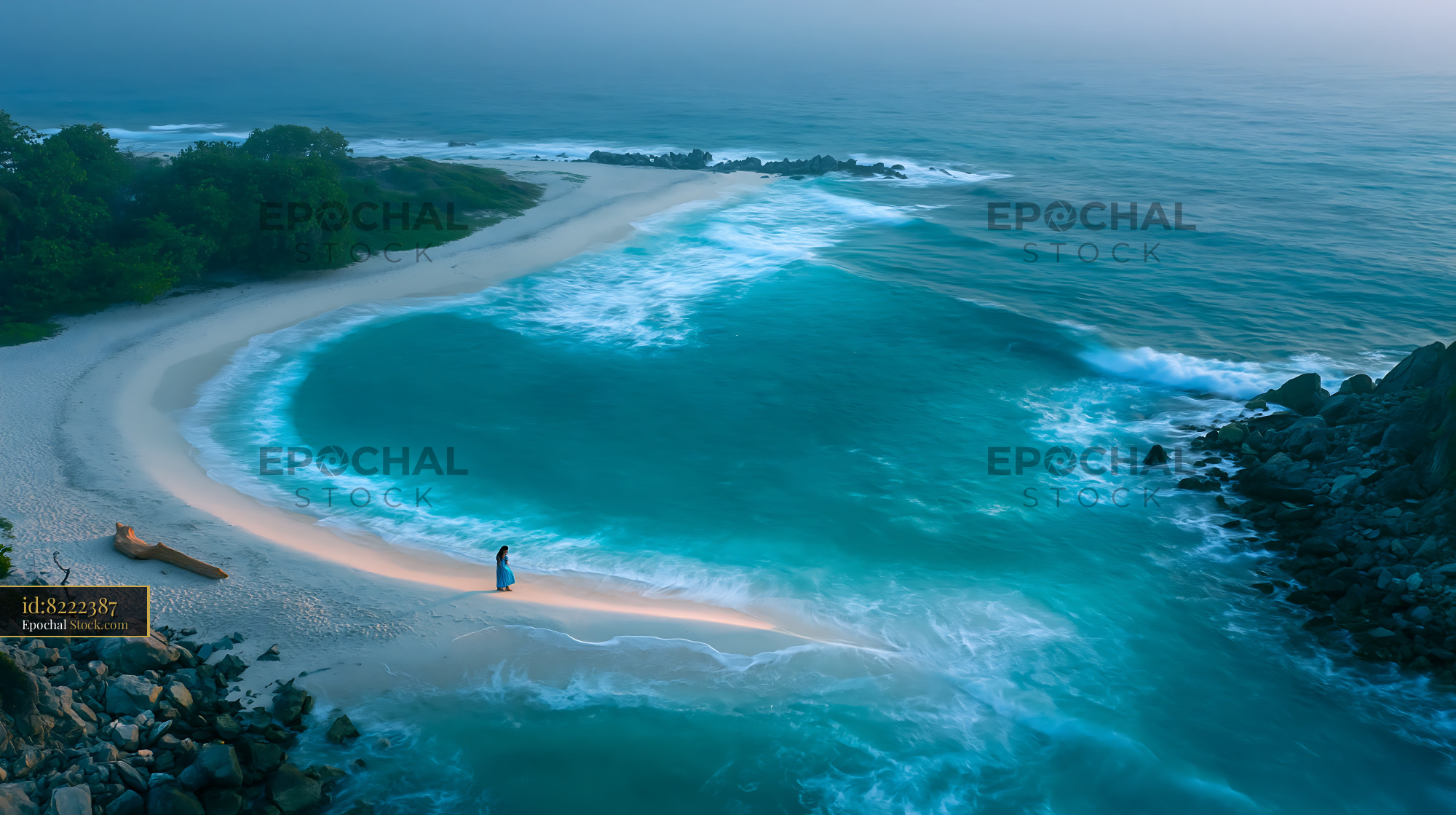 Heart-shaped tropical bay with a lone woman on the beach at dawn - stock photo