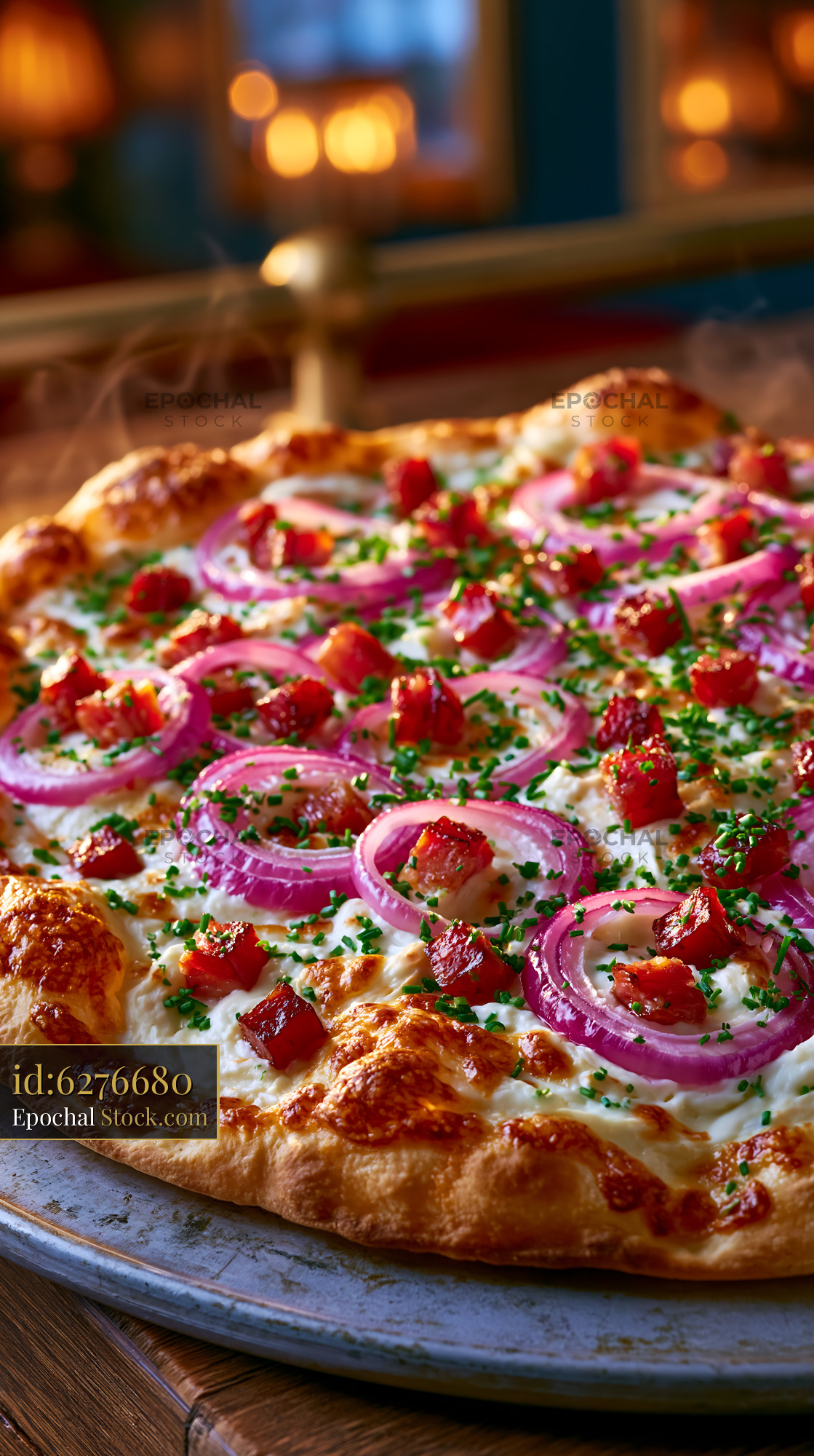Fresh flammkuchen pizza with red onions and bacon in a cozy restaurant - stock photo