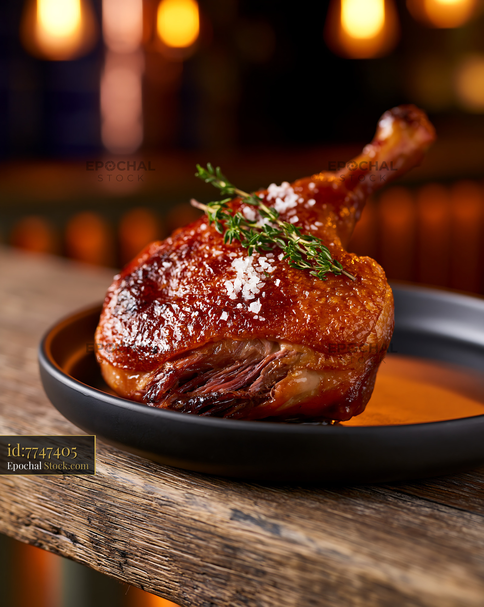 Roasted duck leg confit de canard meat with crispy skin and thyme - stock photo