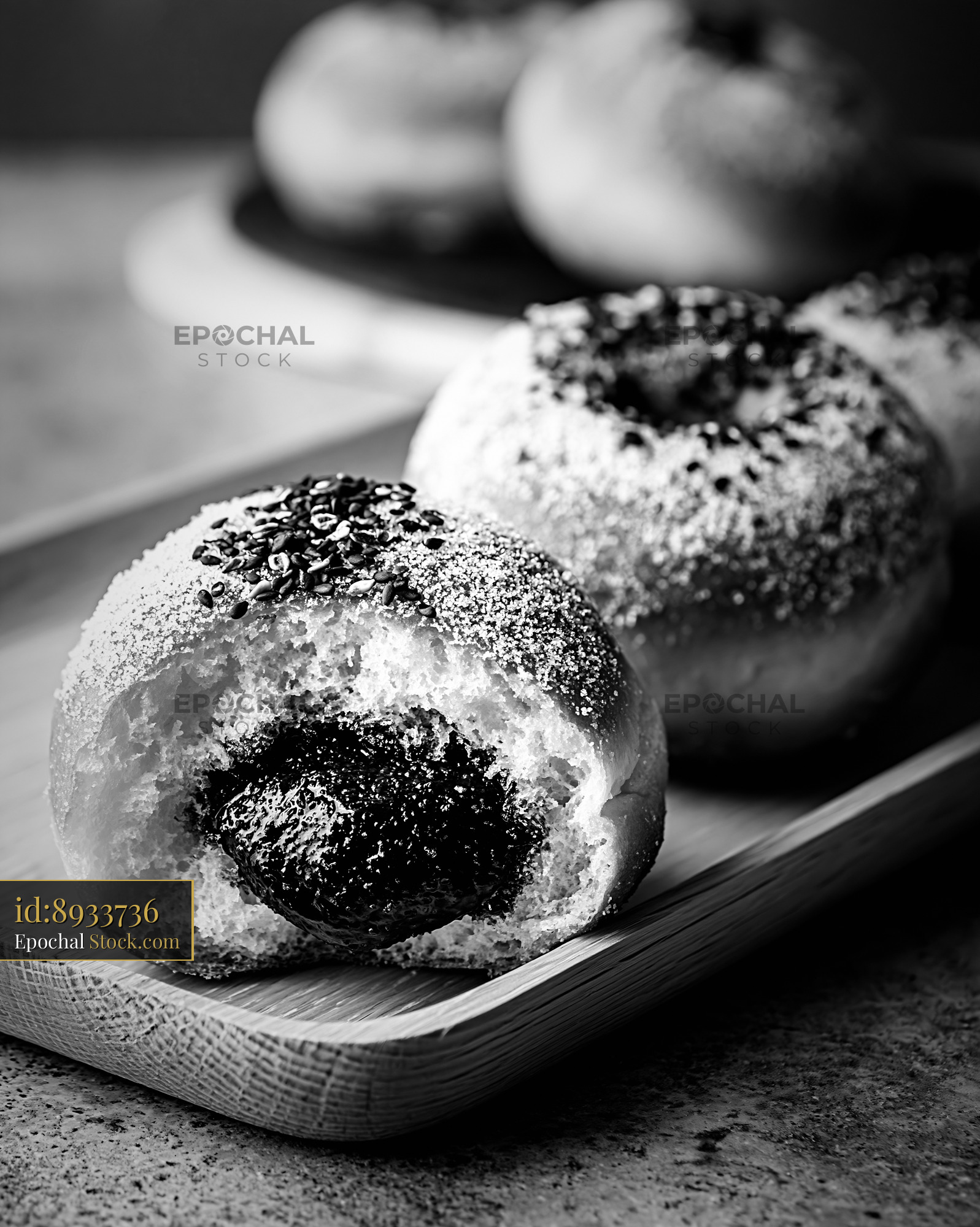 Fresh black sesame paste filled donuts on a rustic wooden tray - stock photo