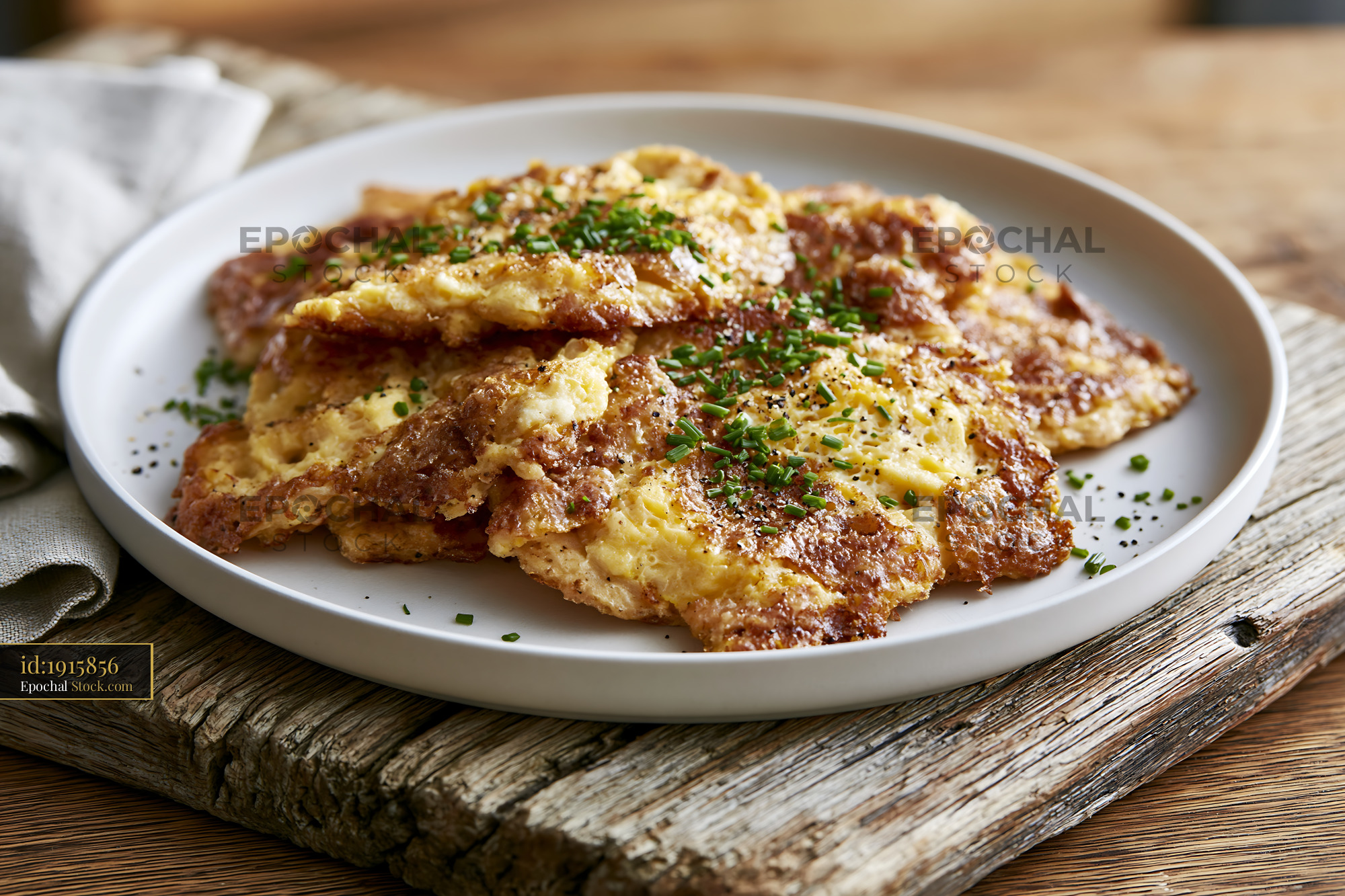 Traditional matzah brei with eggs and chives on a rustic wooden table - stock photo