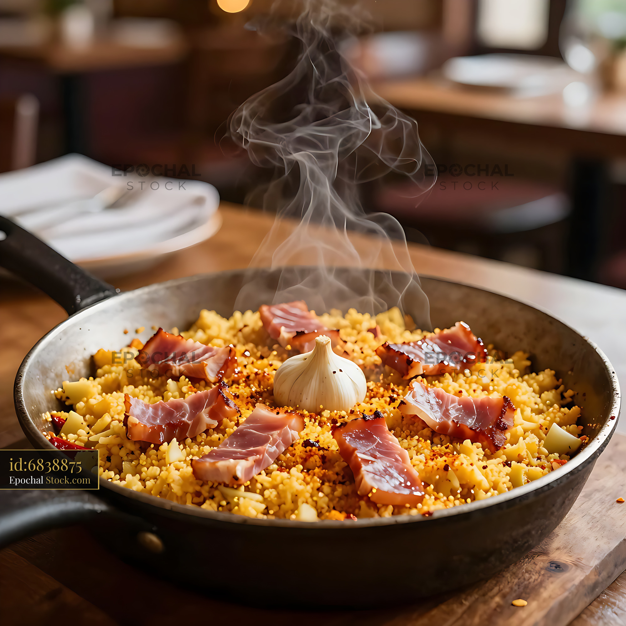 Traditional Migas Extremenas con Jamon in a steaming frying pan - stock photo
