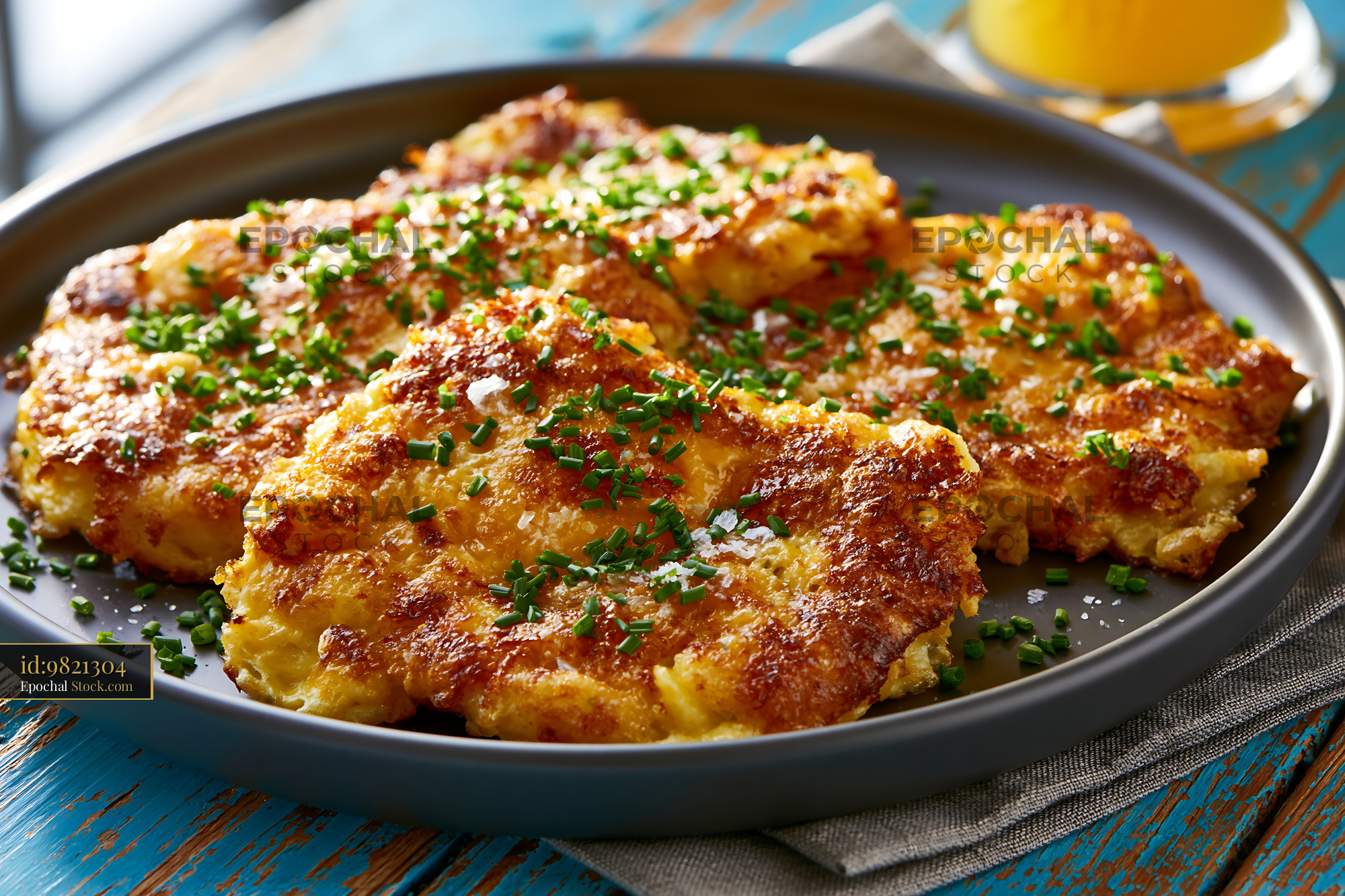 Crispy matzah brei with fresh chives served on a rustic table - stock photo