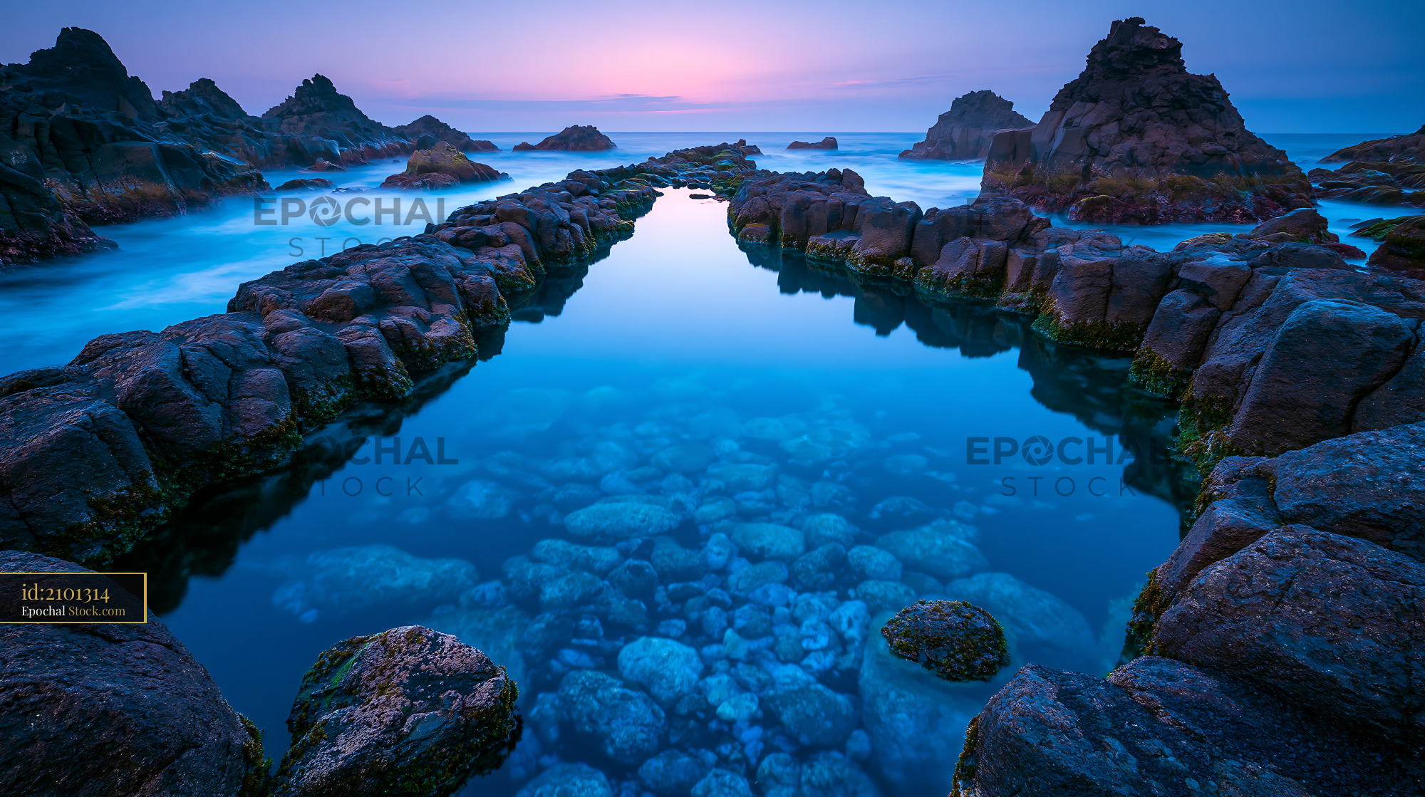 Natural volcanic tide pool with basalt rocks at blue hour in the Azore - stock photo