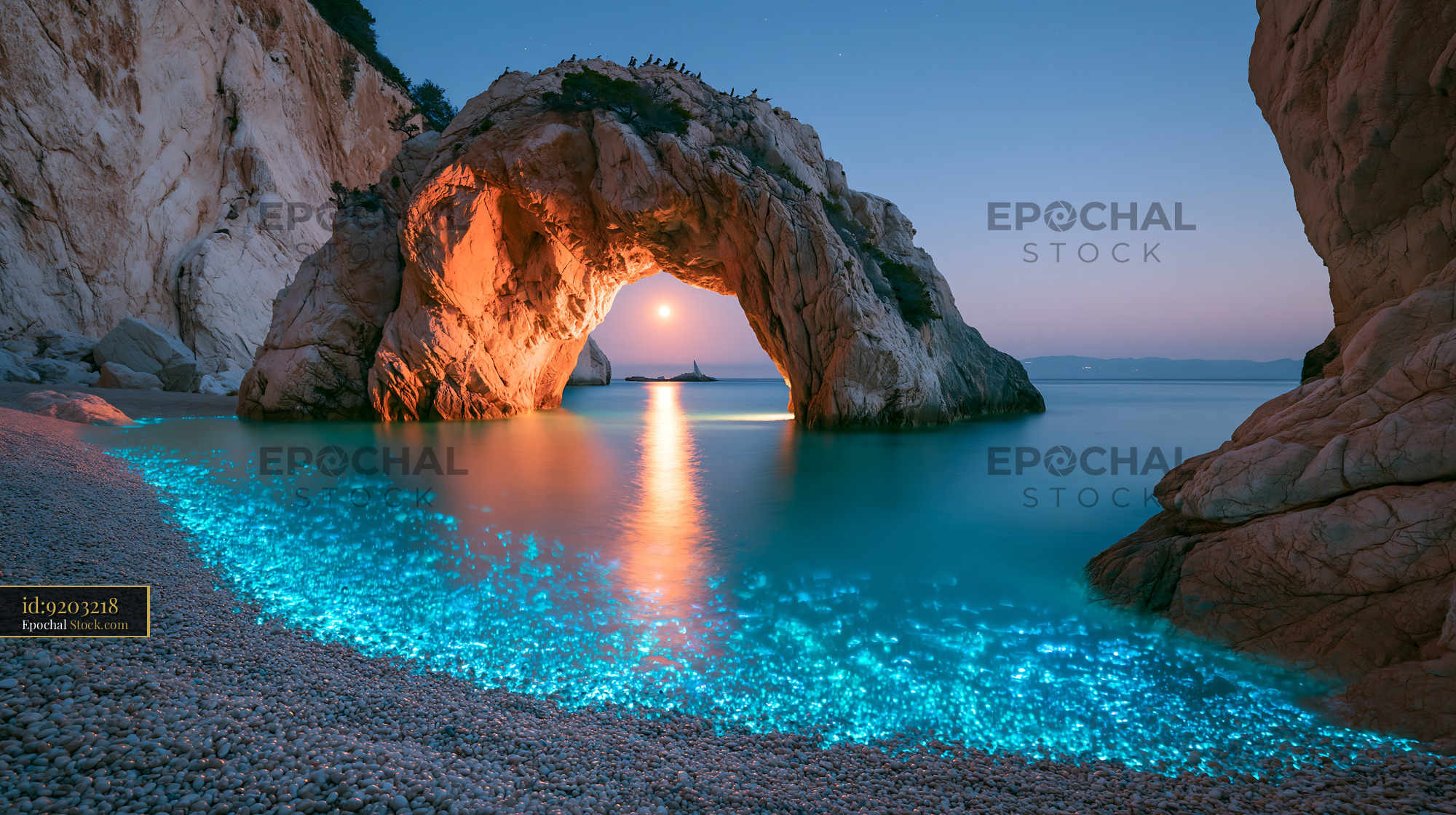 Natural rock arch over bioluminescent water in a hidden Sardinian cove - stock photo