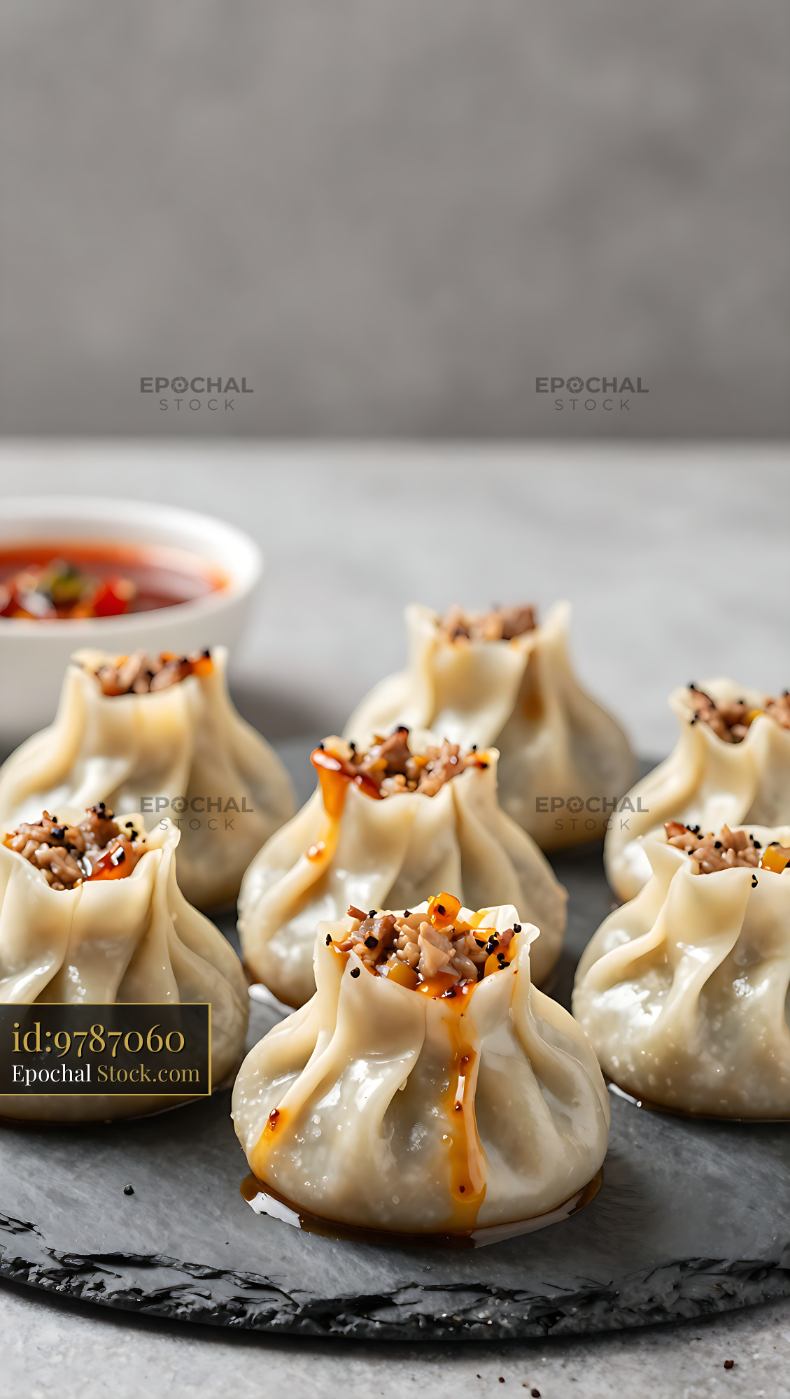 Tibetan pork momo dumplings served on a slate plate with chili oil - stock photo
