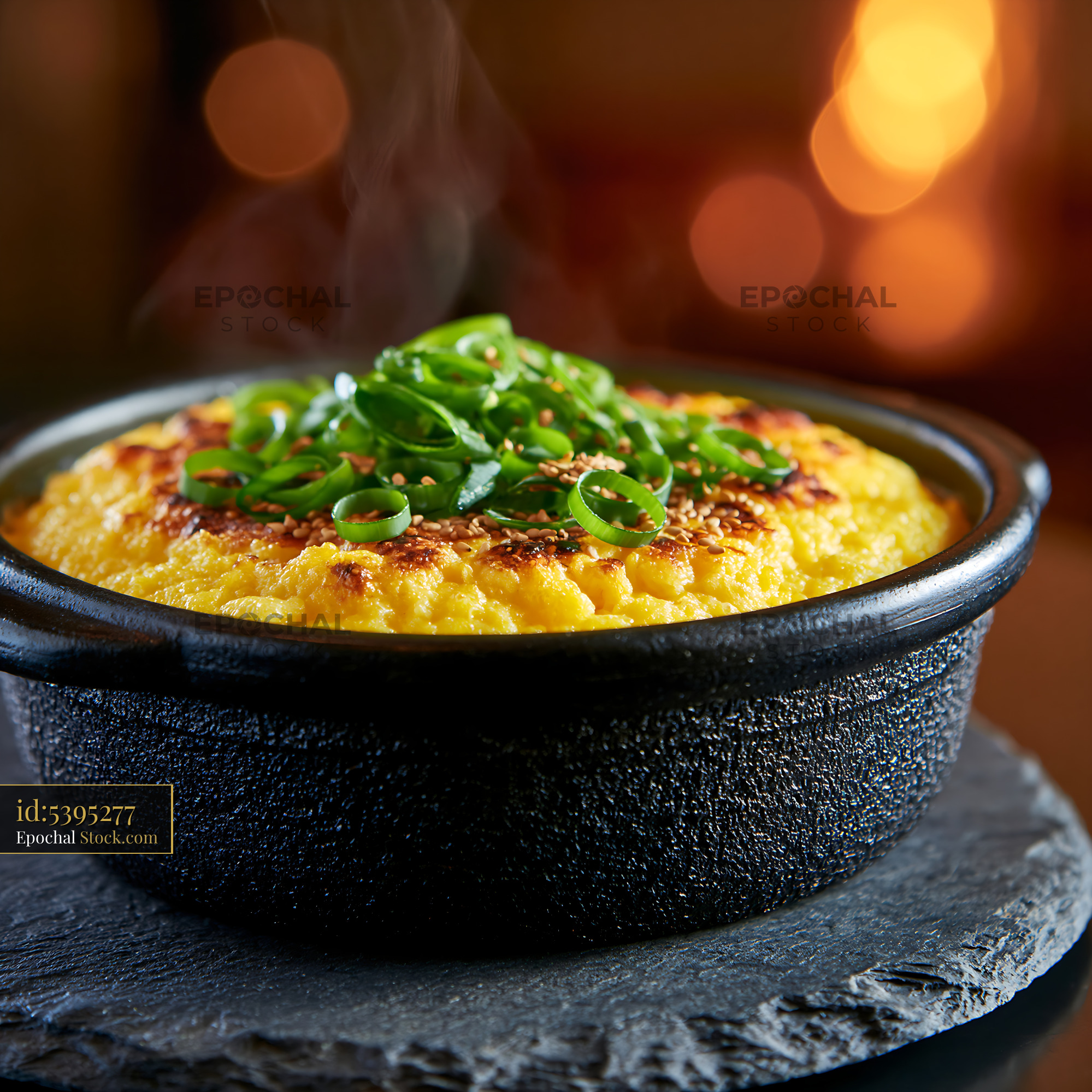 Hot gyeran-jjim Korean steamed egg topped with scallions in a stone po - stock photo