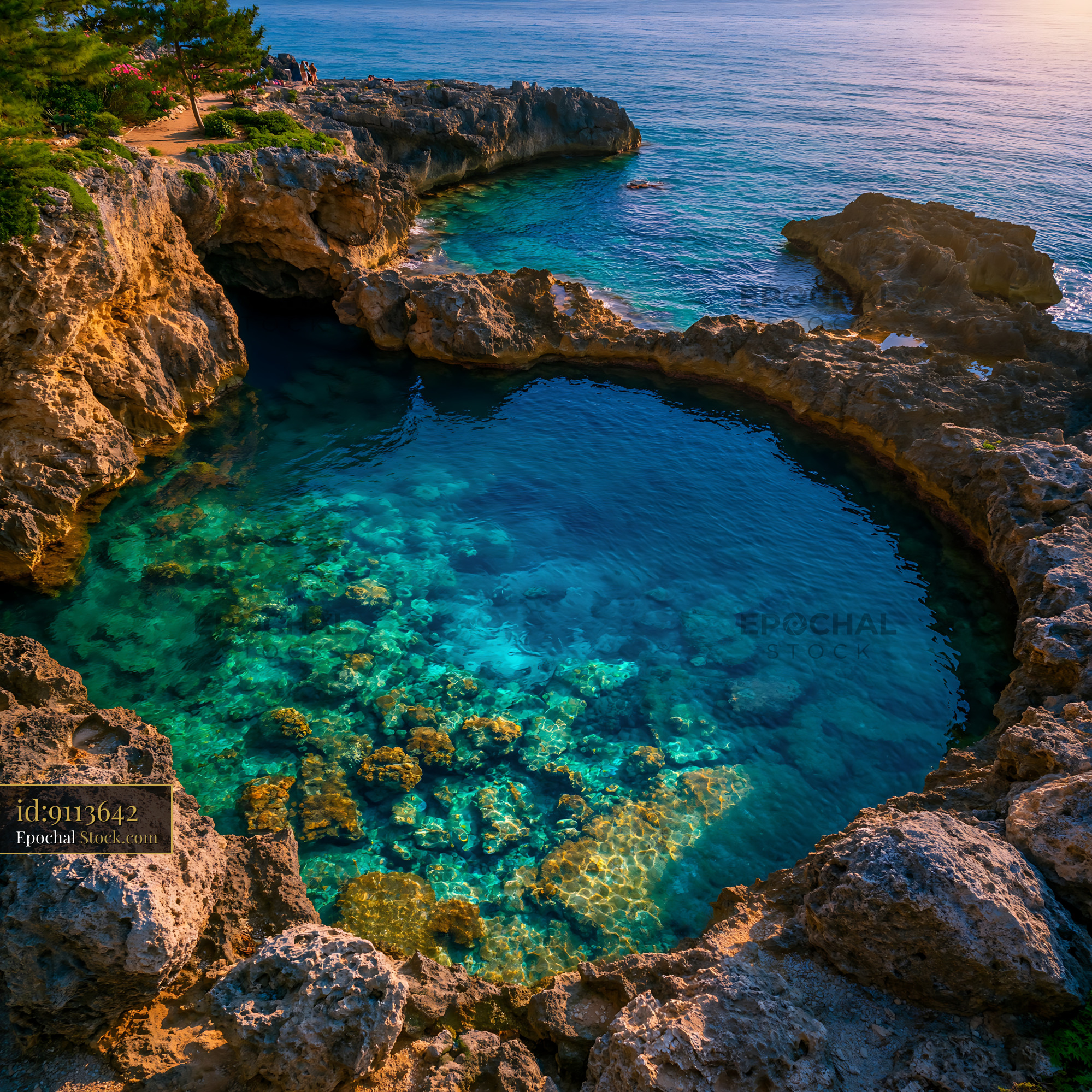 Aerial view of a crystal clear coral pool surrounded by coastal rocks - stock photo