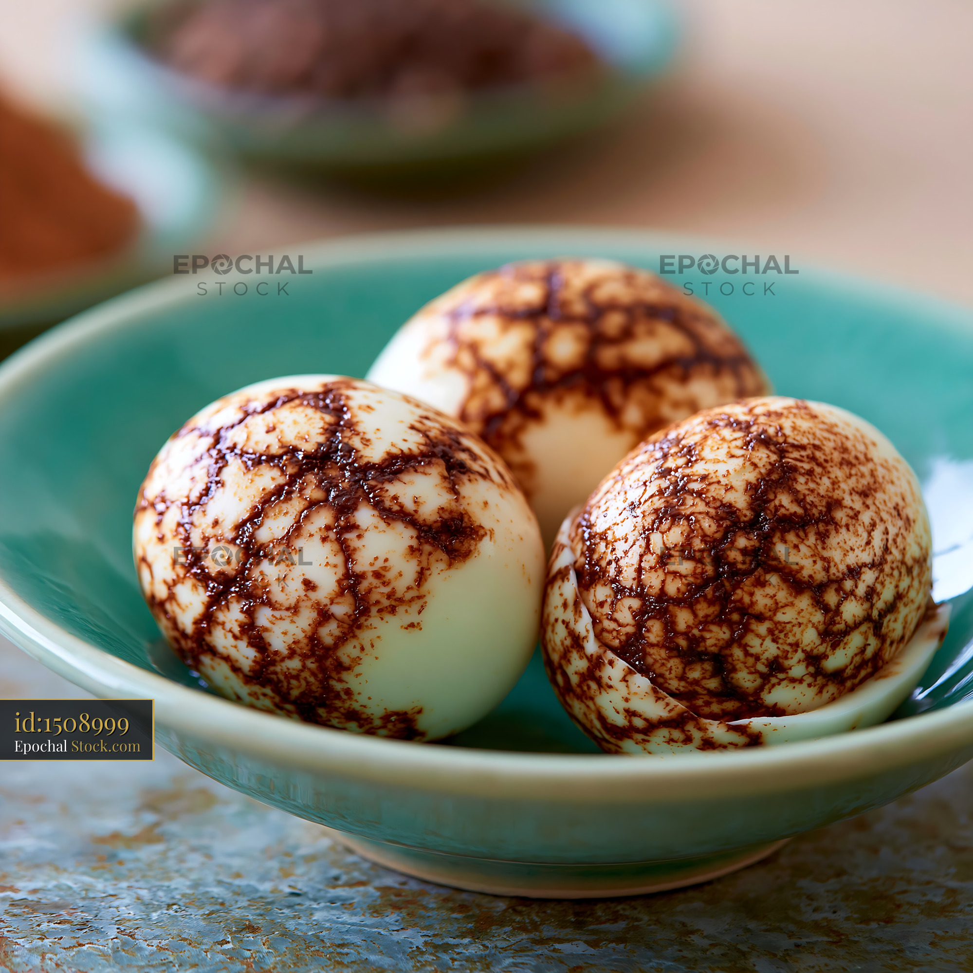 Traditional Chinese marbled tea eggs in a turquoise ceramic bowl - stock photo
